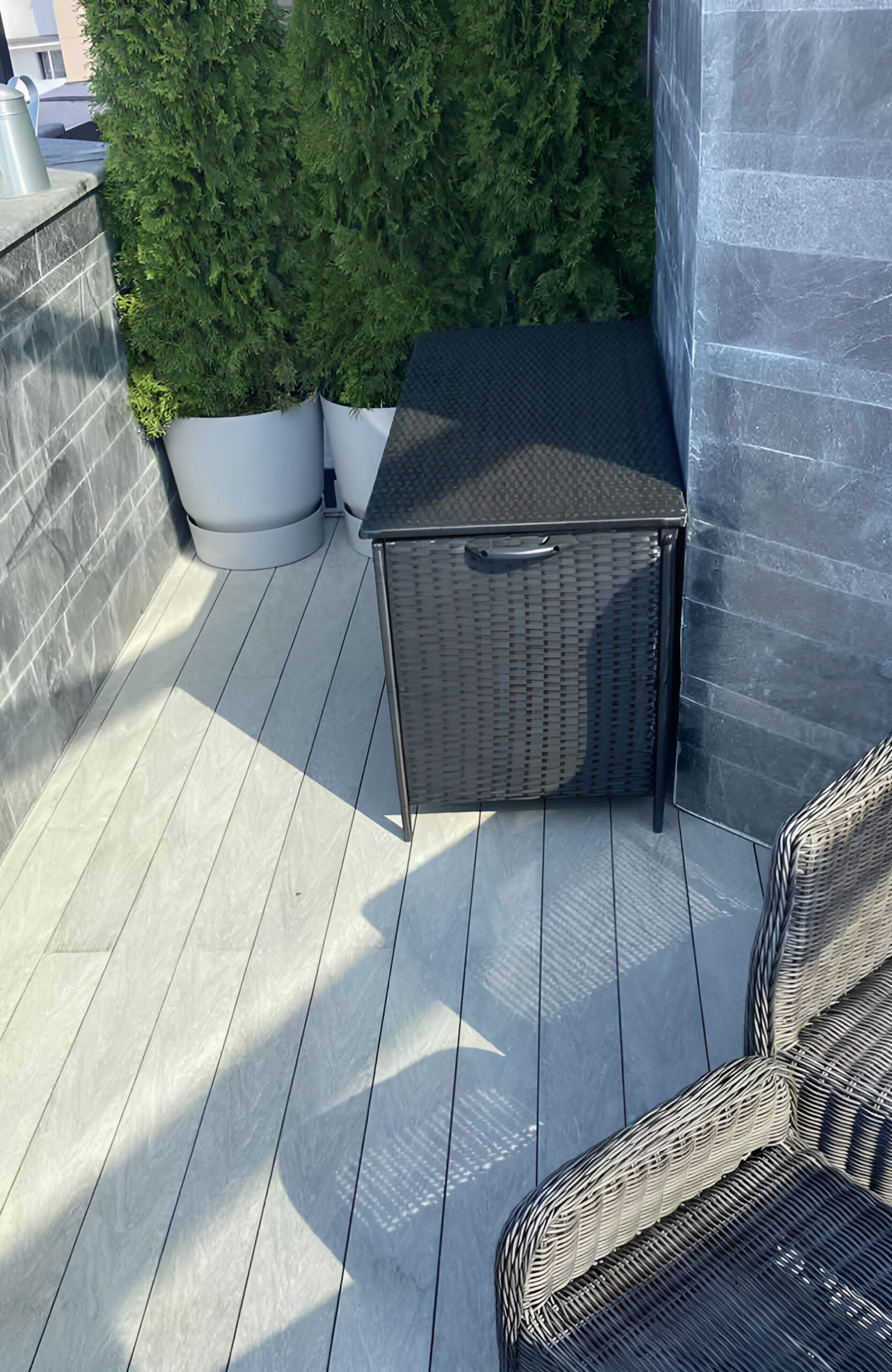 Urban balcony with BRUGGAN Multicolor grey composite decking, seating area and panoramic glazing