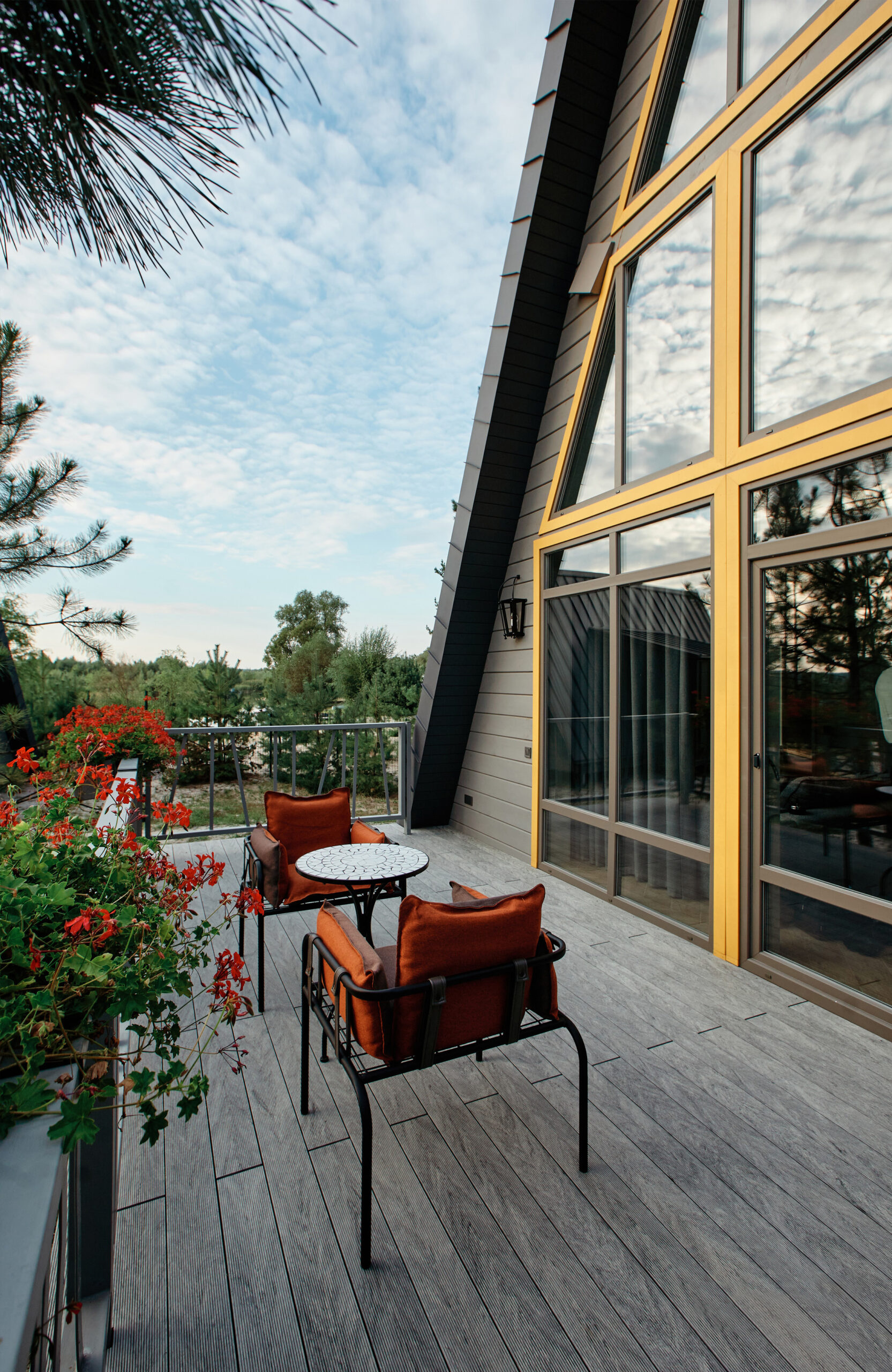 Grey BRUGGAN Multicolor composite decking on a modern outdoor terrace surrounded by pine trees
