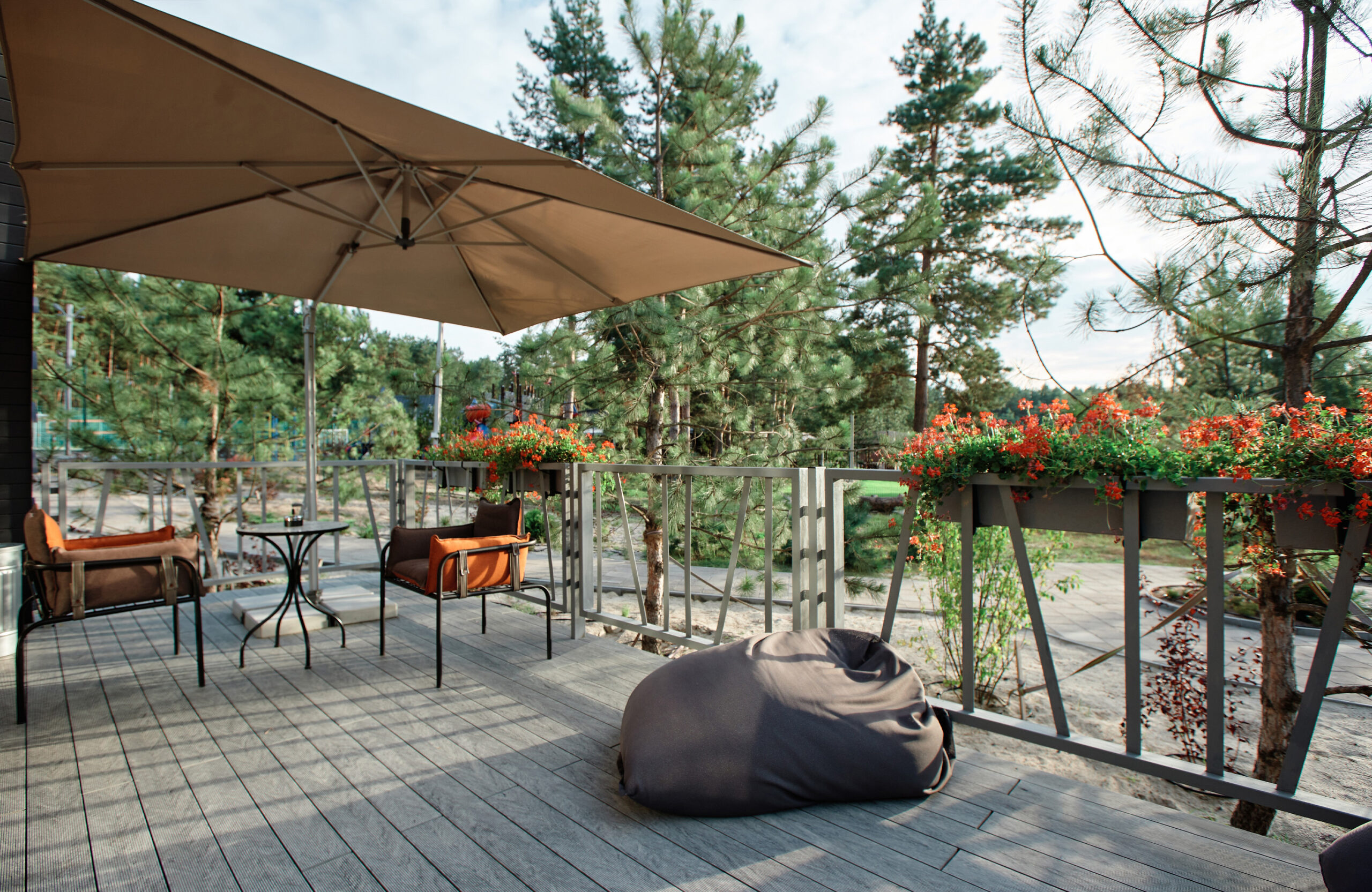 Grey BRUGGAN Multicolor composite decking on a modern outdoor terrace surrounded by pine trees