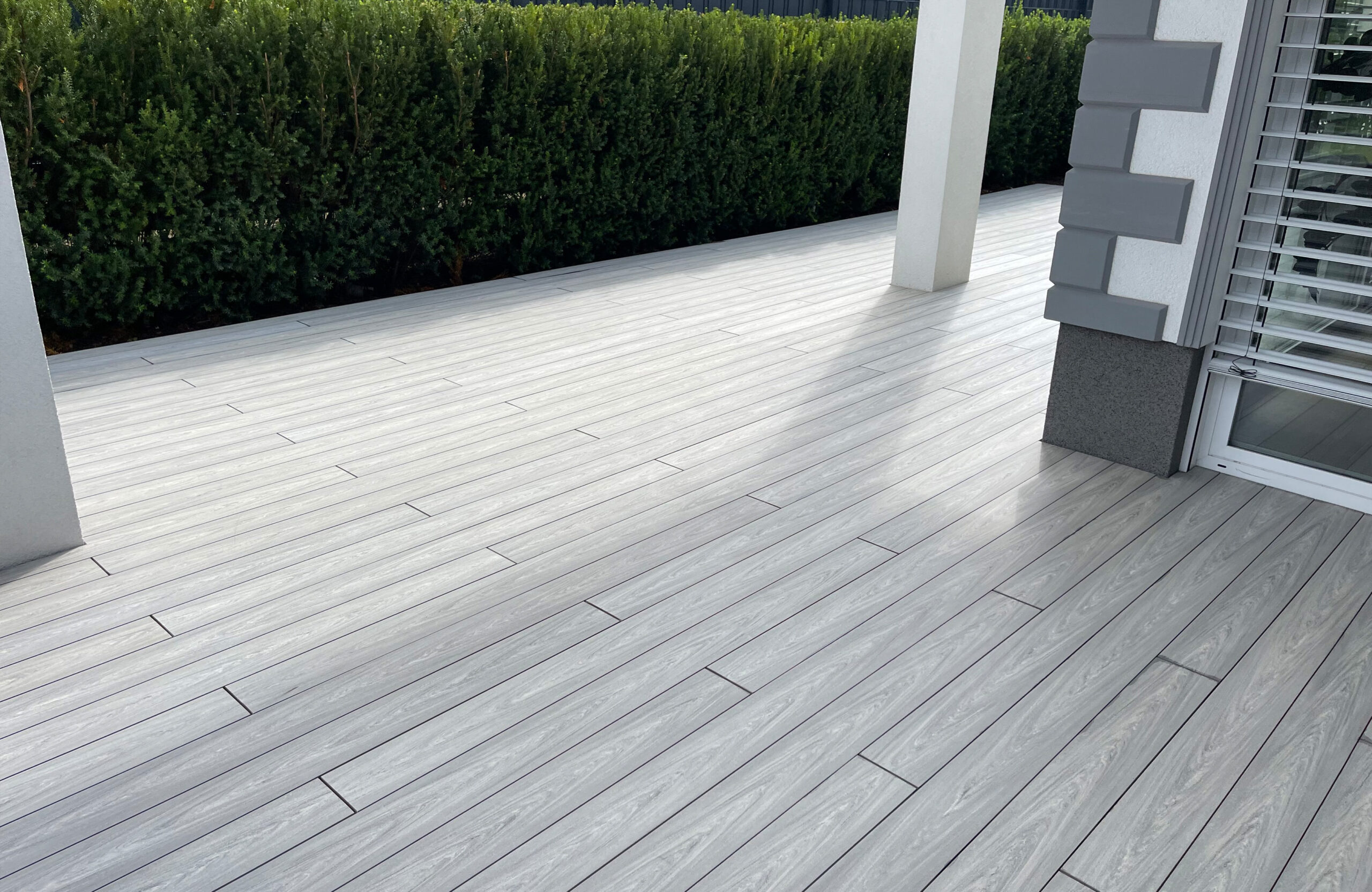 BRUGGAN Multicolor grey composite decking on a modern residential terrace with outdoor furniture