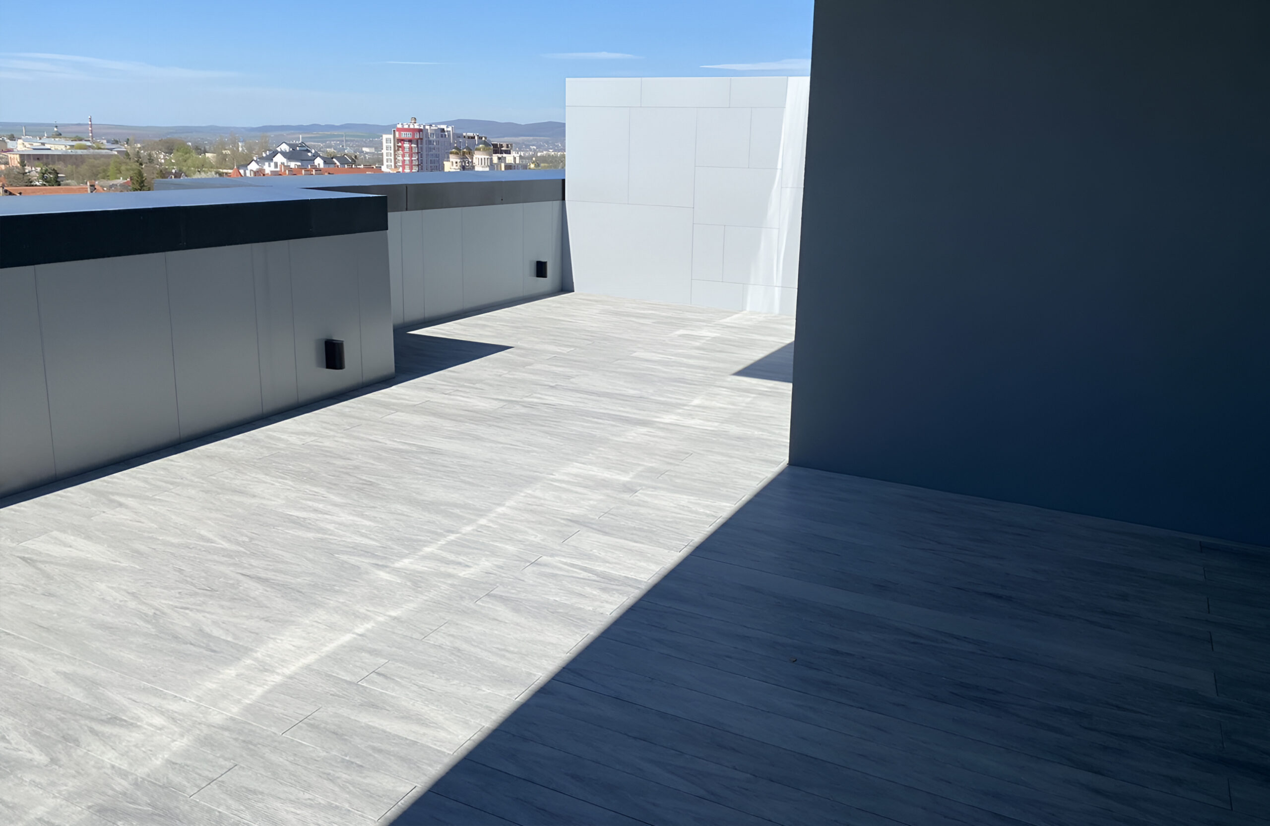 Stylish urban rooftop terrace featuring BRUGGAN Multicolor grey composite decking and modern outdoor design
