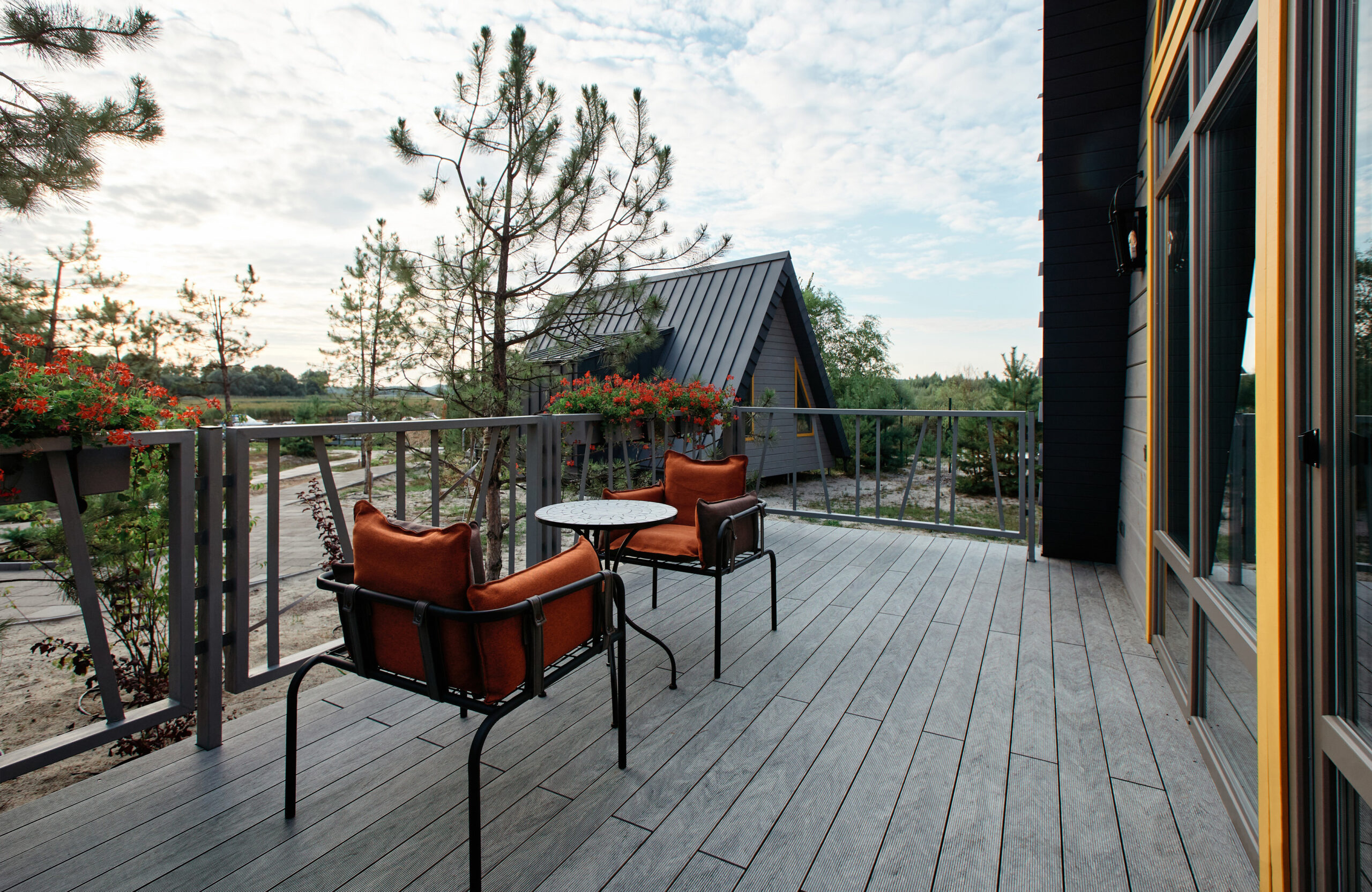 Grey BRUGGAN Multicolor composite decking on a modern outdoor terrace surrounded by pine trees