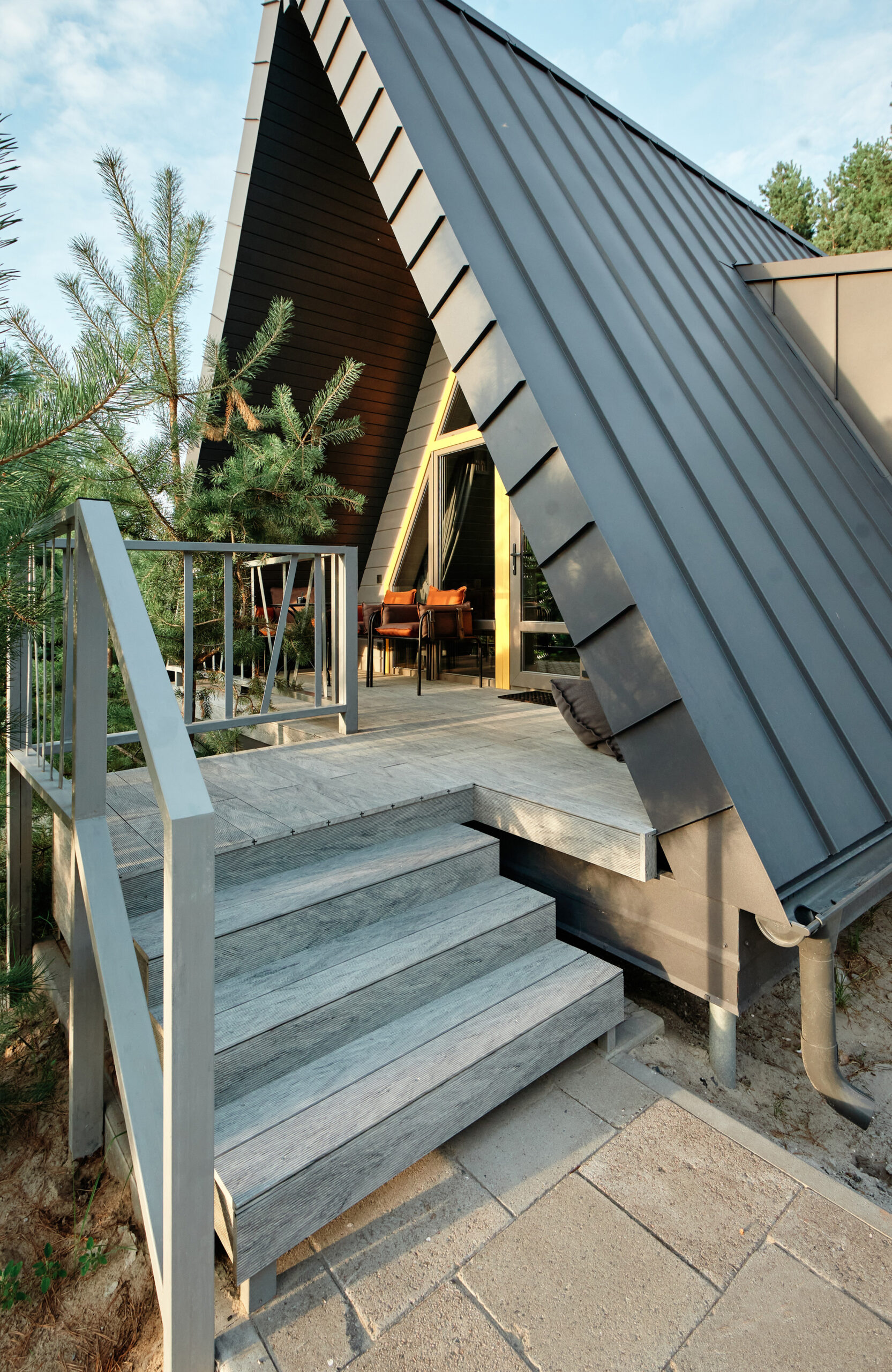 Grey BRUGGAN Multicolor composite decking on a modern outdoor terrace surrounded by pine trees