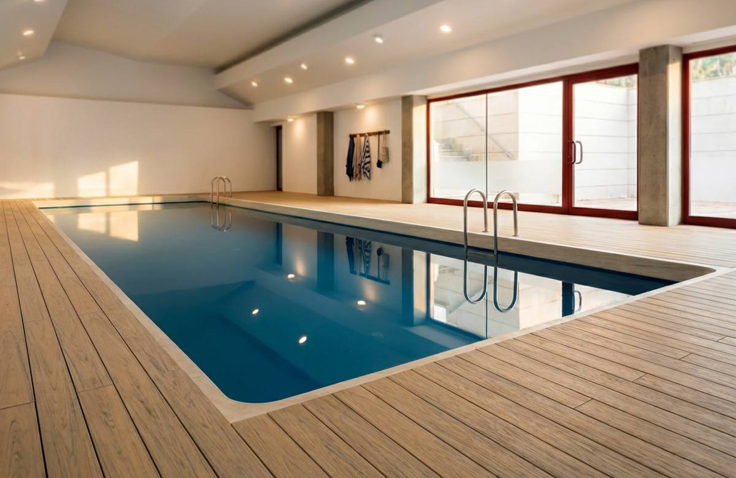 Indoor pool area finished with BRUGGAN Multicolor composite decking in sand color.