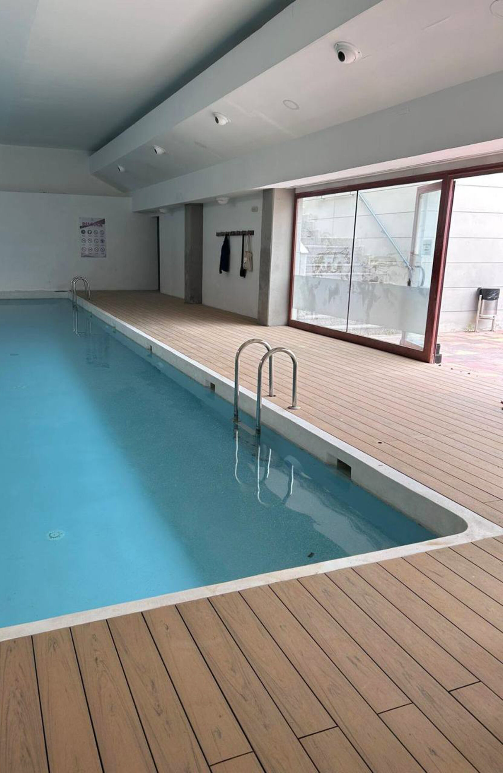 Indoor pool area finished with BRUGGAN Multicolor composite decking in sand color.