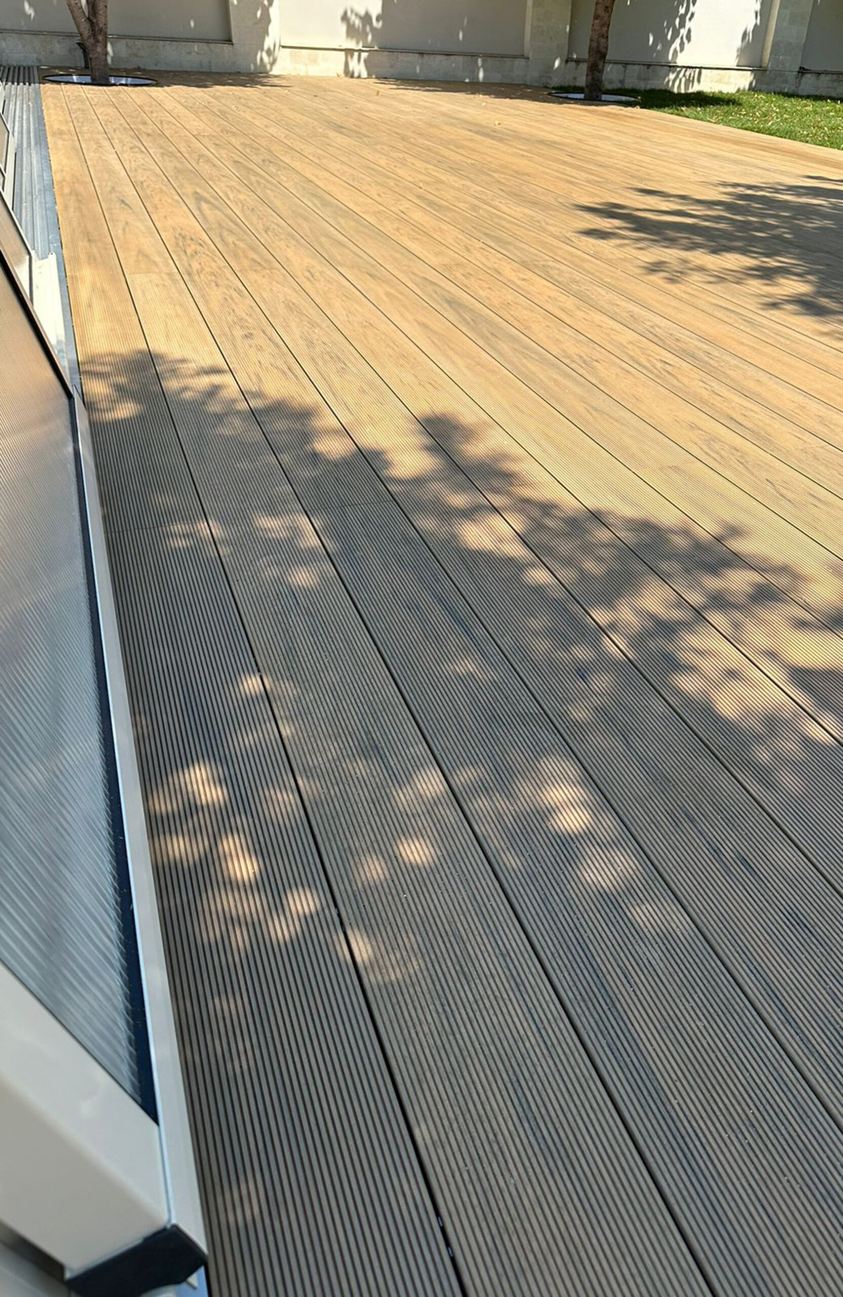 Outdoor pool area finished with BRUGGAN Multicolor decking in sand color