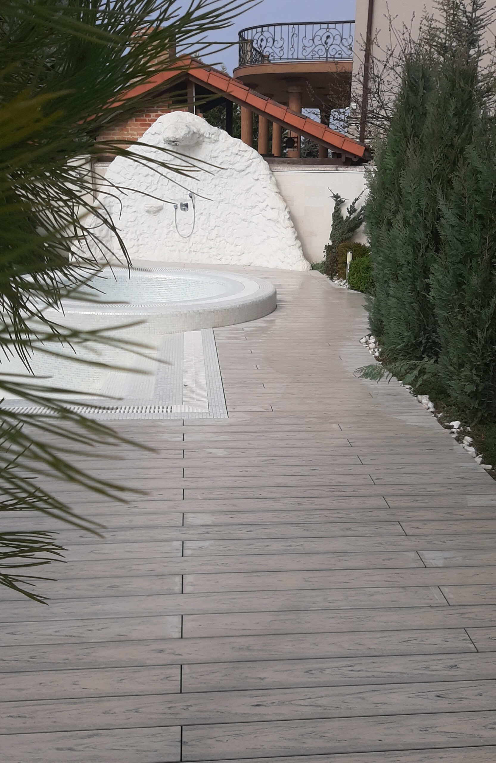 Smoke White composite decking for a landscaped pool area with curved edges