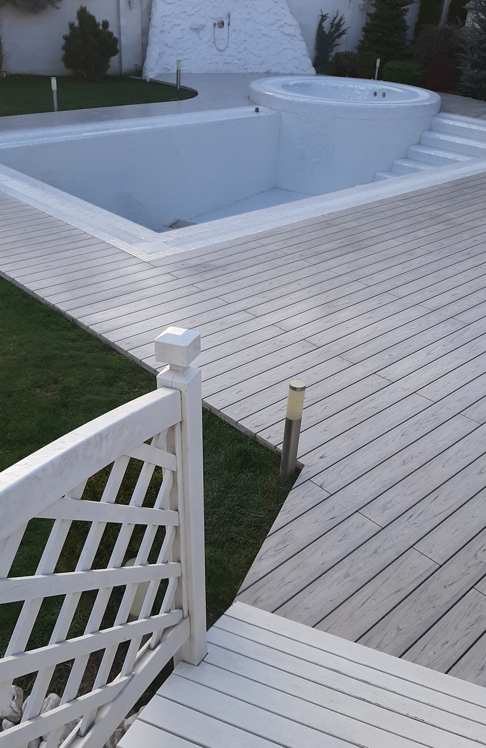 Modern pool terrace finished with light grey wood-effect composite decking