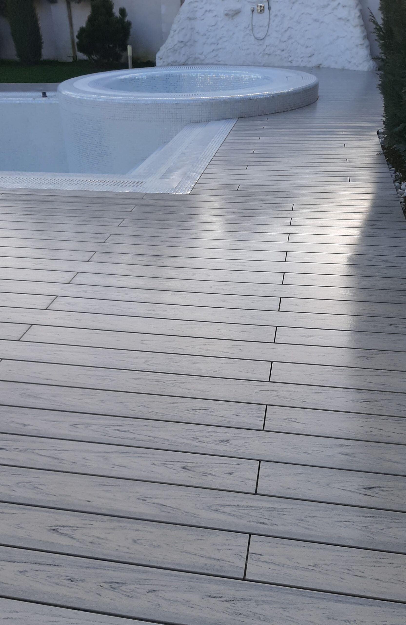 Modern pool terrace finished with light grey wood-effect composite decking