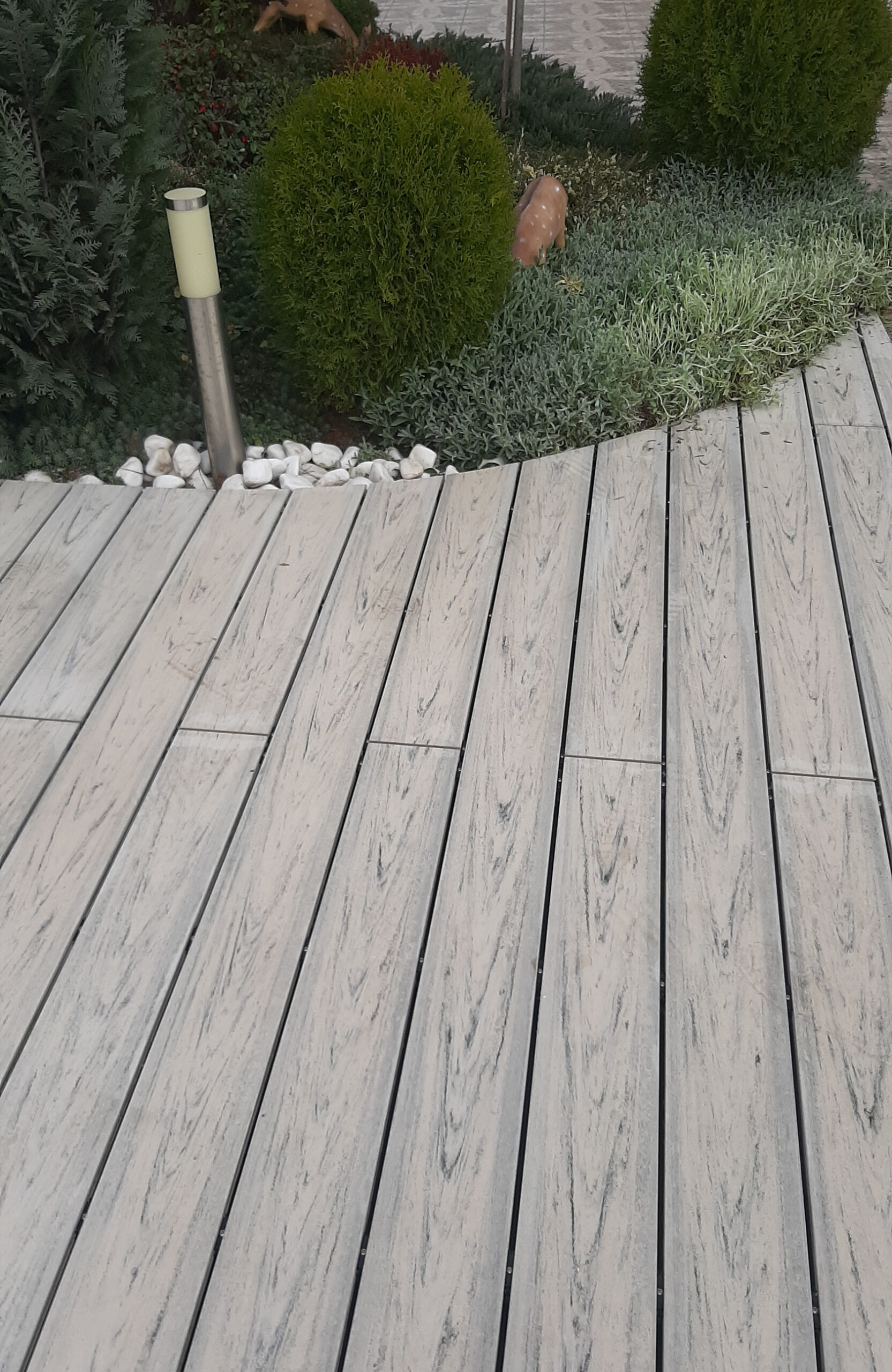 Smoke White composite decking for a landscaped pool area with curved edges