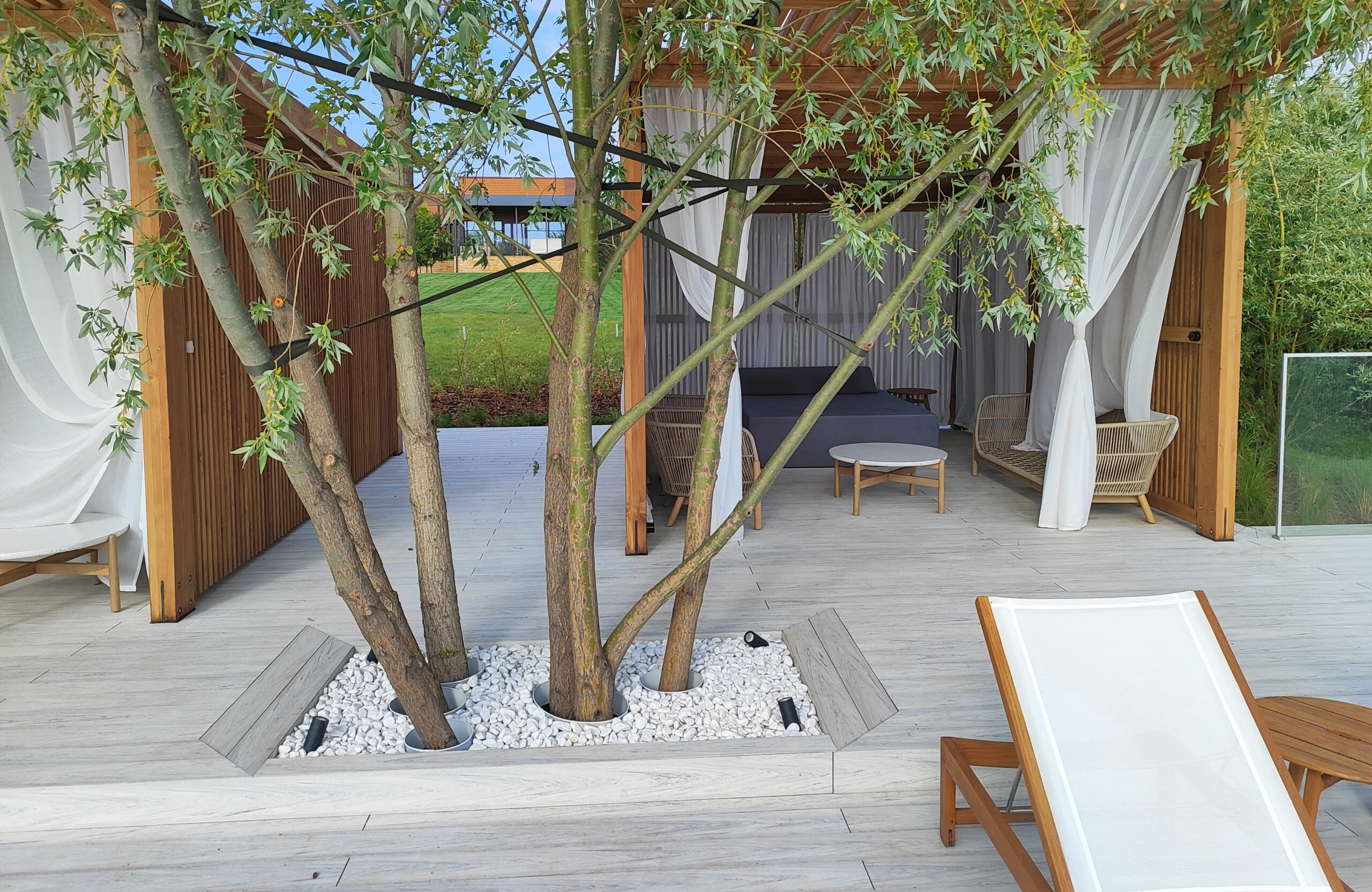 Modern lakeside terrace with light composite decking, lounge areas and glass railing
