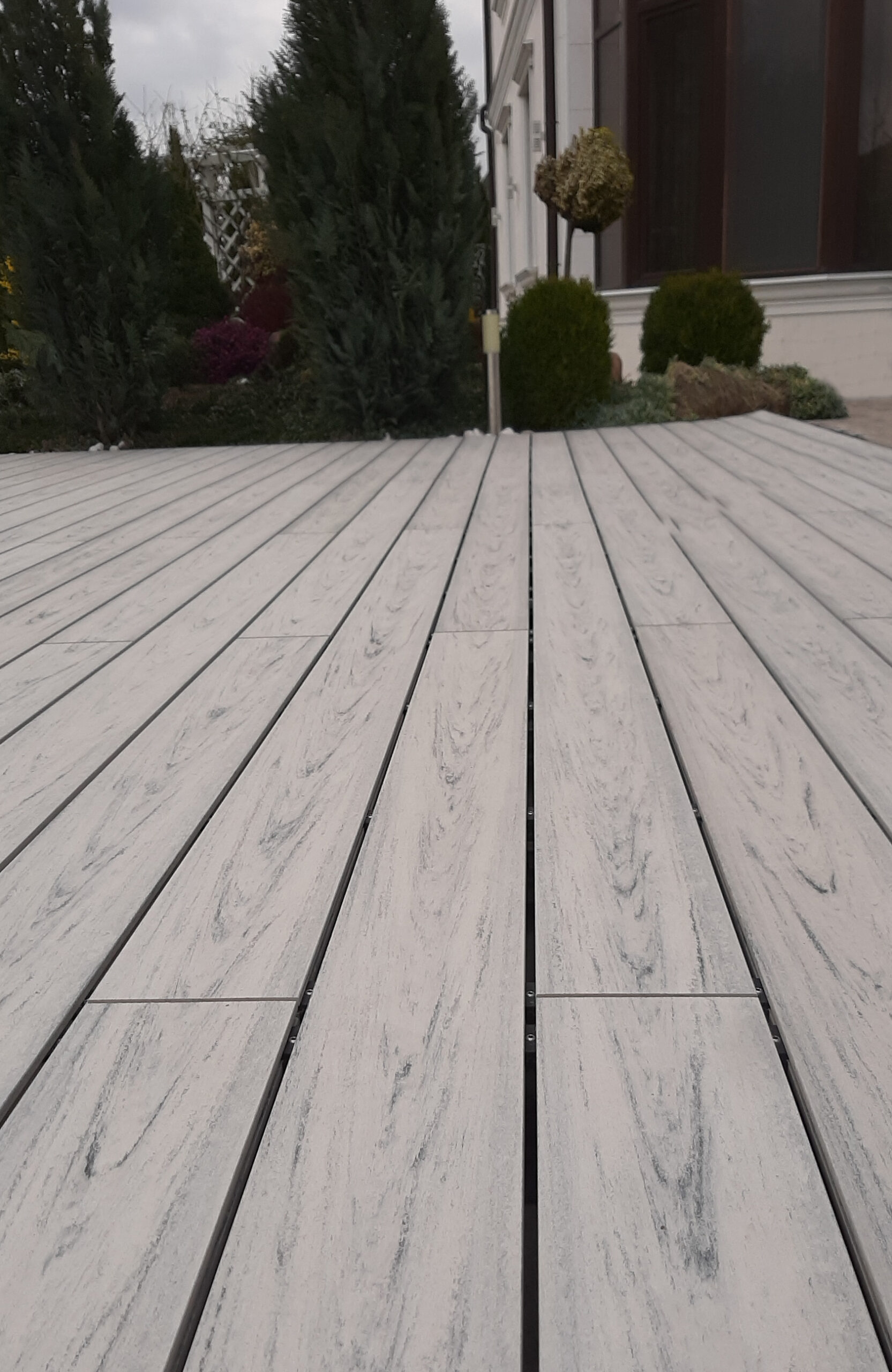 Smoke White composite decking for a landscaped pool area with curved edges