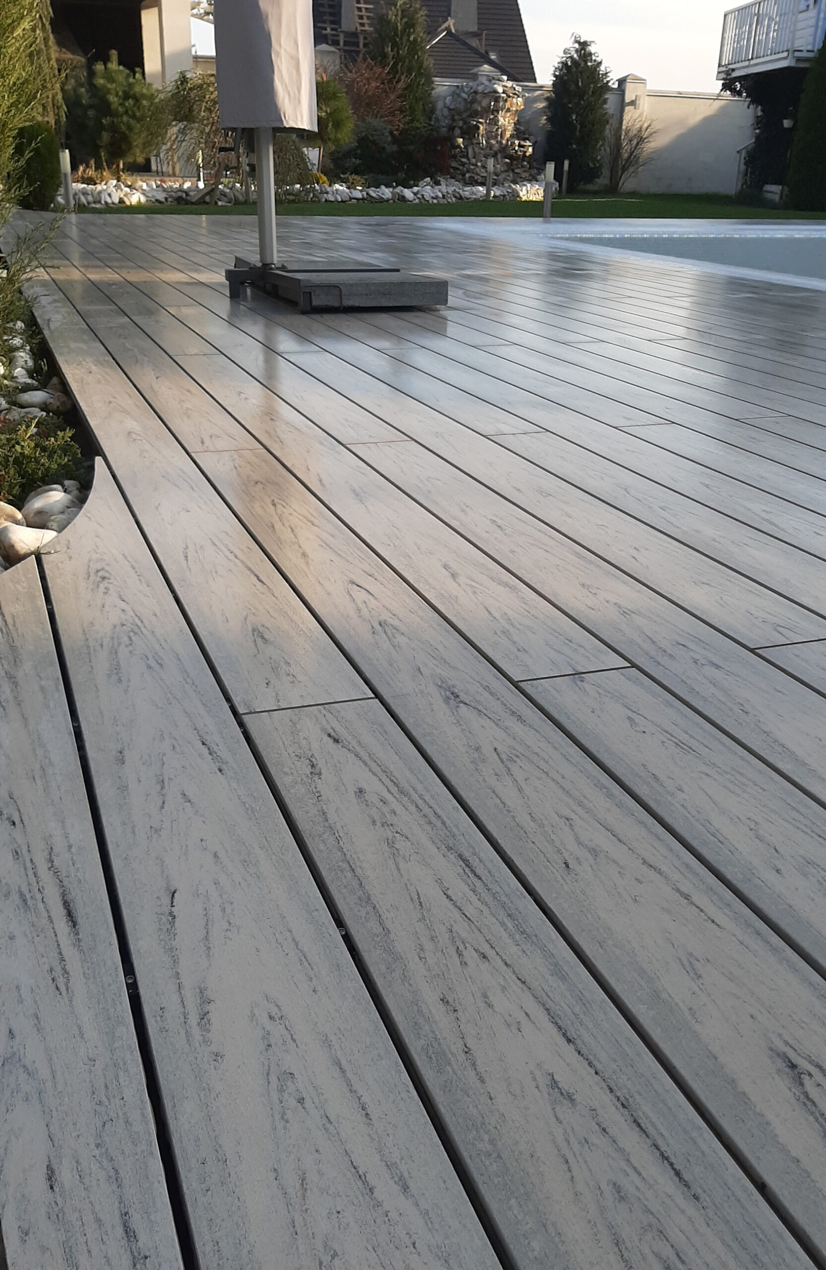 Modern pool terrace finished with light grey wood-effect composite decking