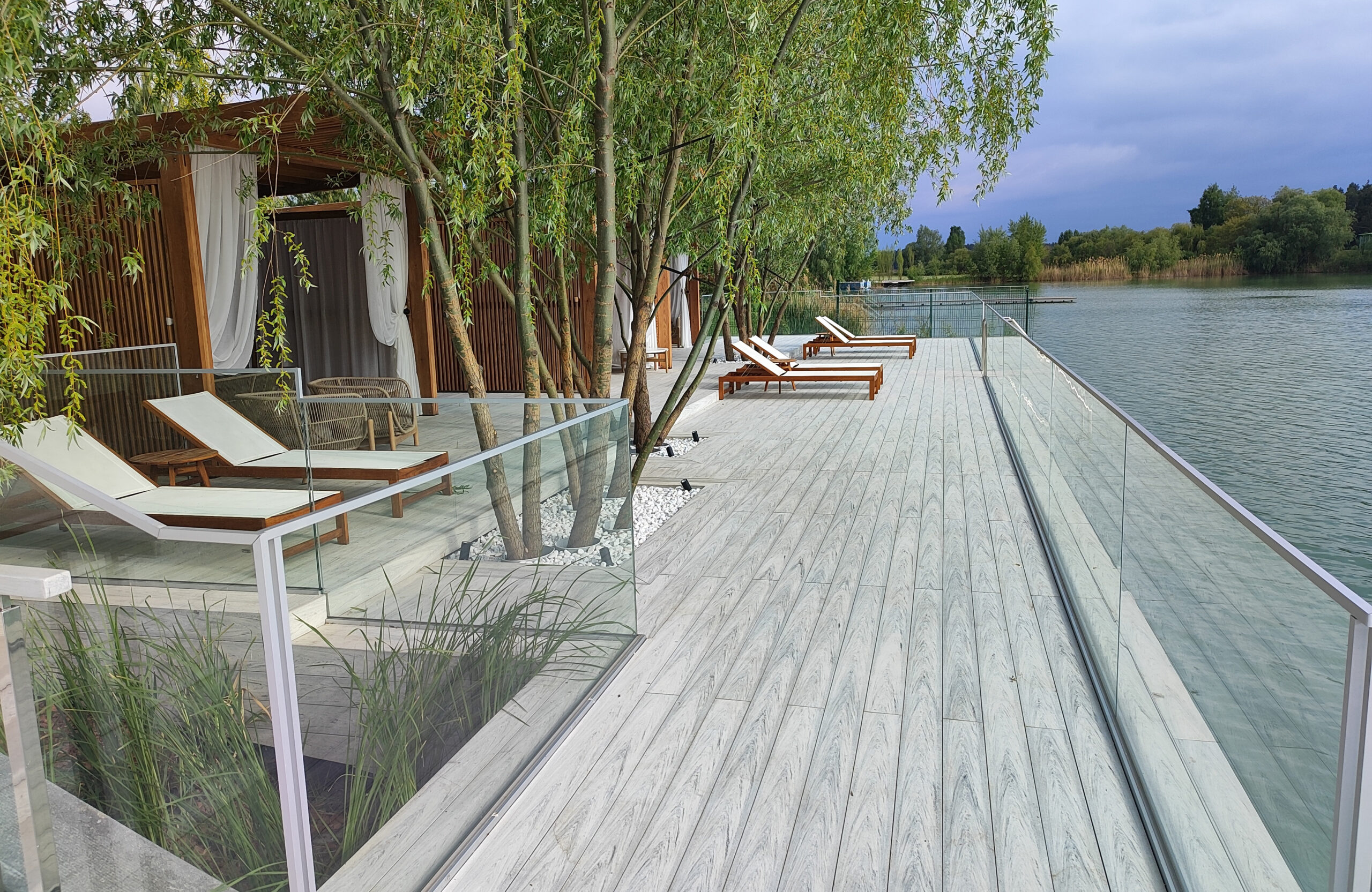 Beach terrace with Smoke White composite decking, sun loungers and lake view
