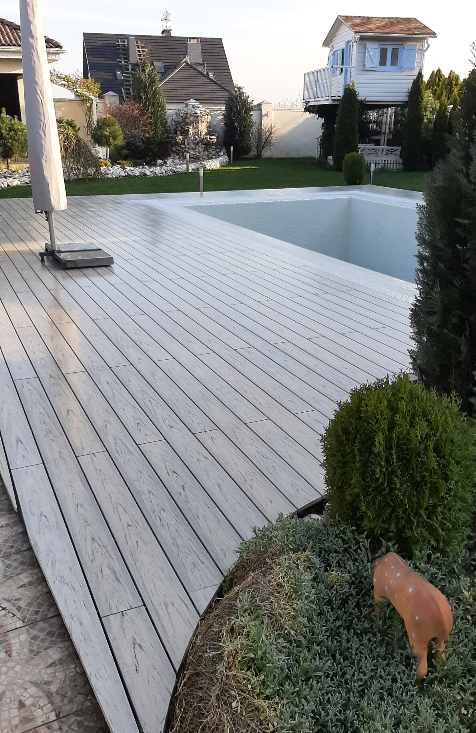 Modern pool terrace finished with light grey wood-effect composite decking