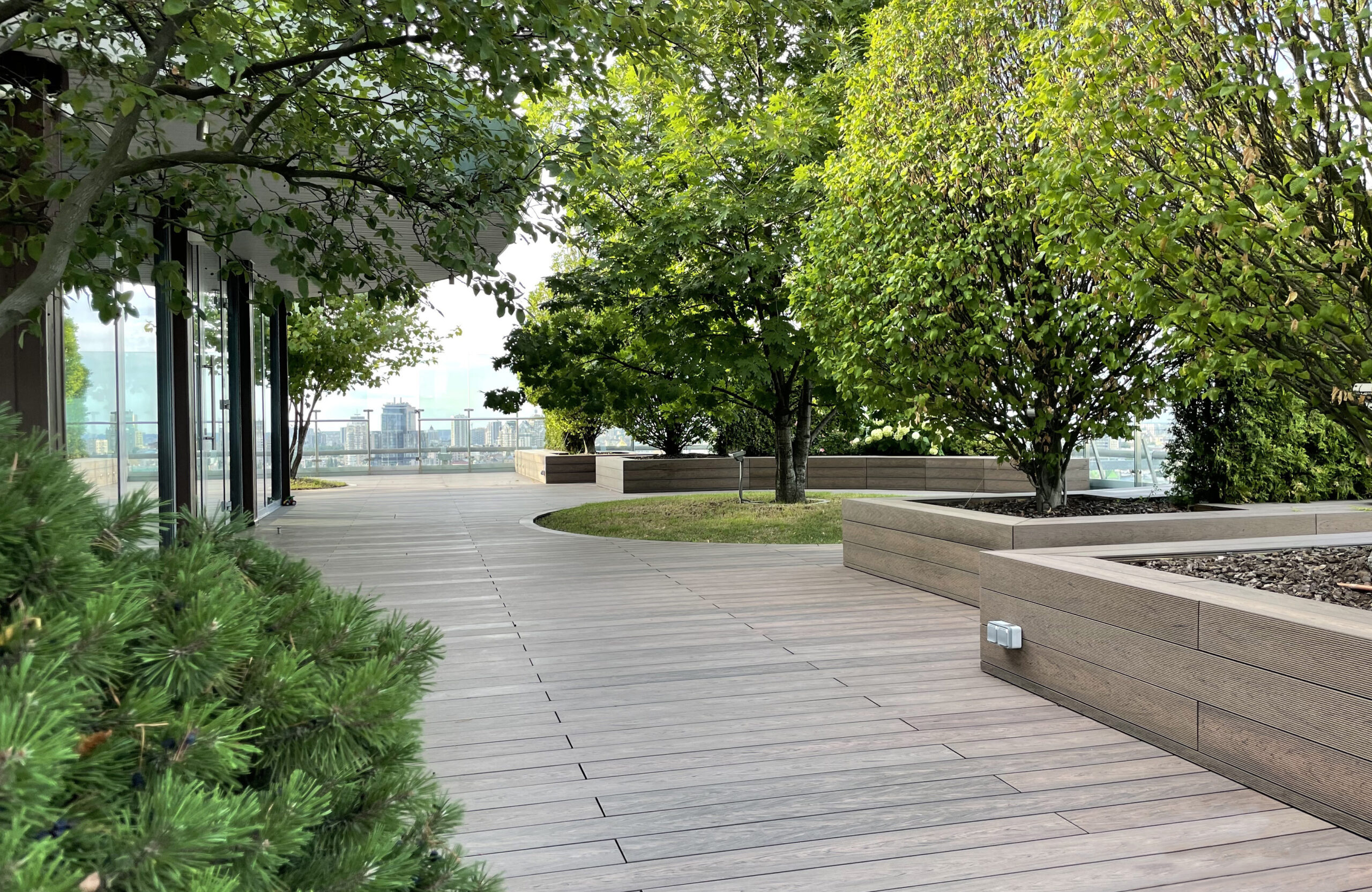 Rooftop landscape park in Kyiv with BRUGGAN Multicolor Wenge composite decking and integrated planters