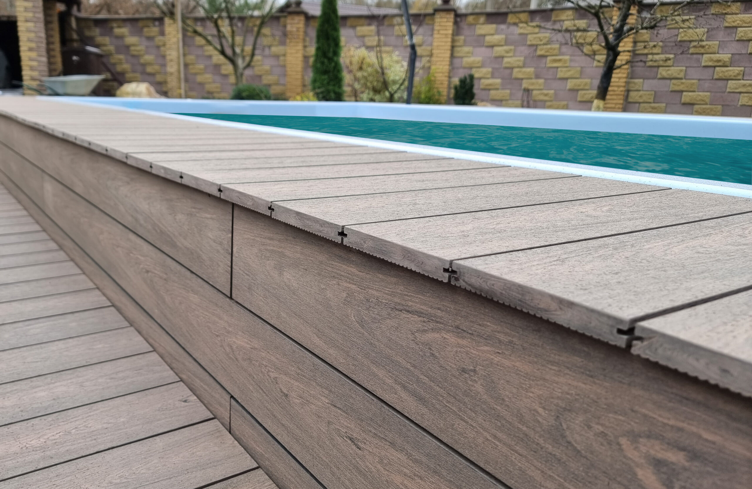 BRUGGAN Multicolor Wenge outdoor decking surrounding a raised swimming pool in a private backyard