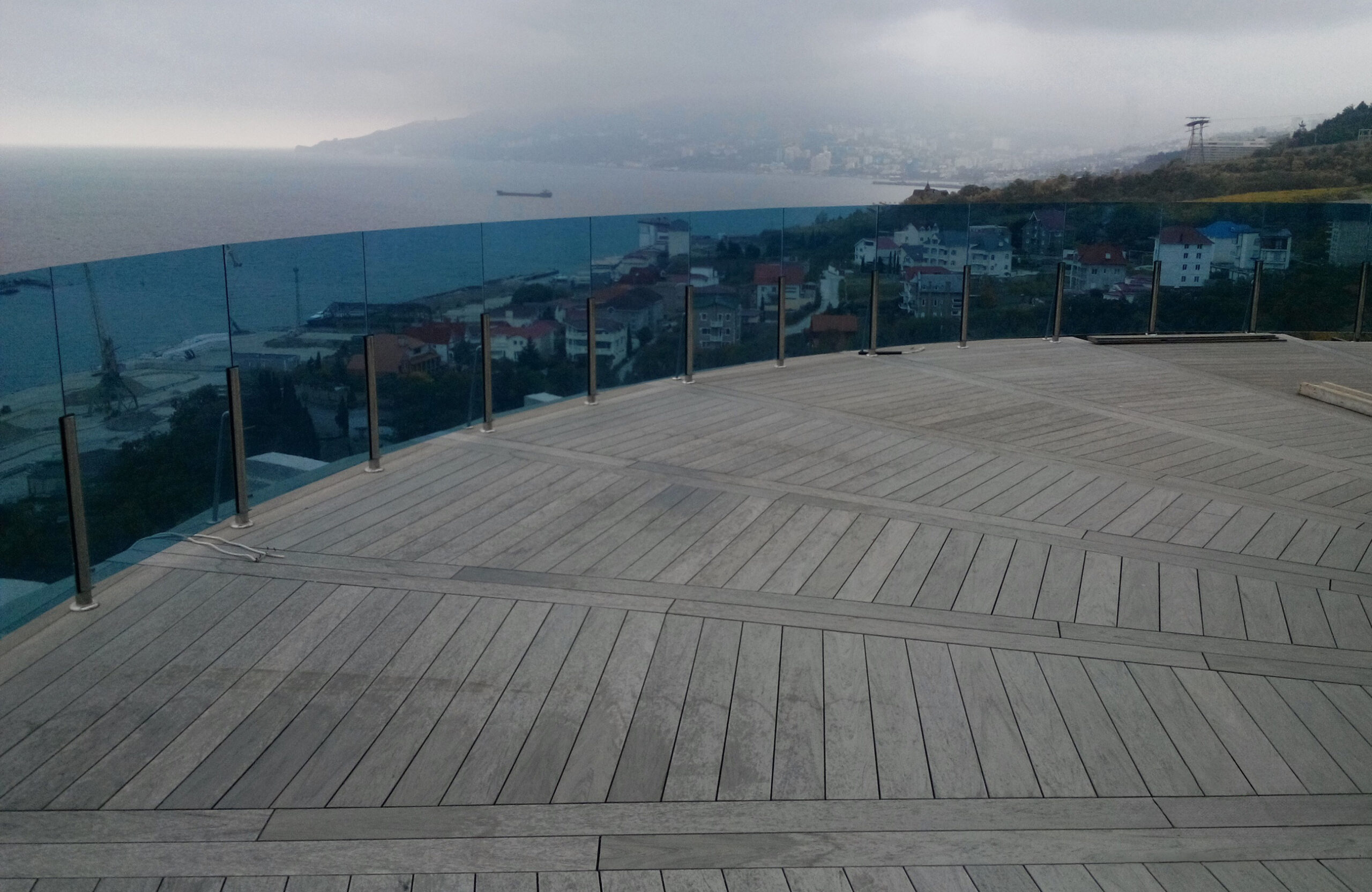 Spacious rooftop terrace finished with BRUGGAN Multicolor Wenge decking and glass railing