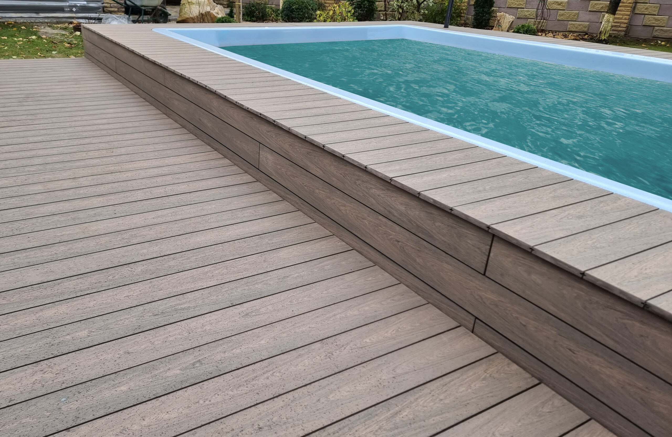 BRUGGAN Multicolor Wenge outdoor decking surrounding a raised swimming pool in a private backyard