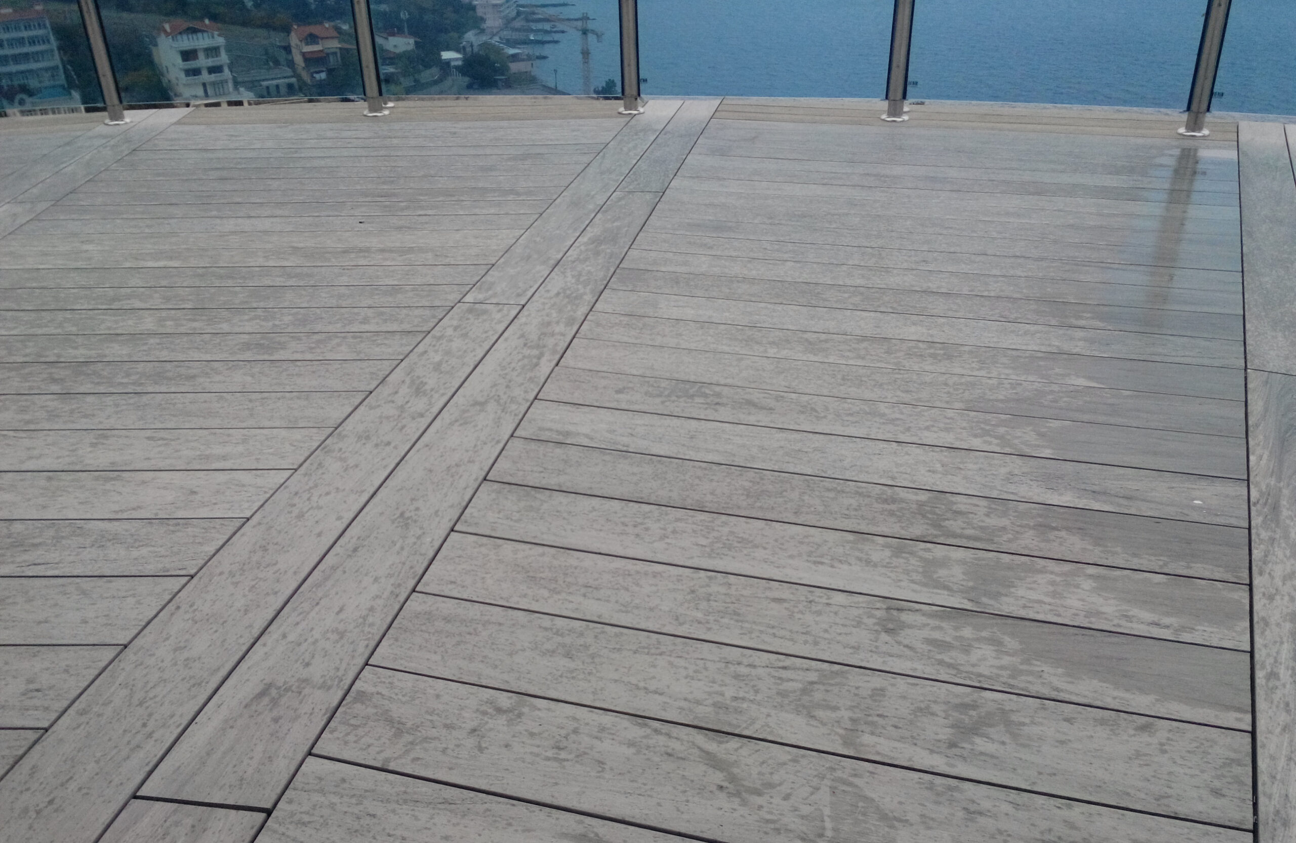 Spacious rooftop terrace finished with BRUGGAN Multicolor Wenge decking and glass railing
