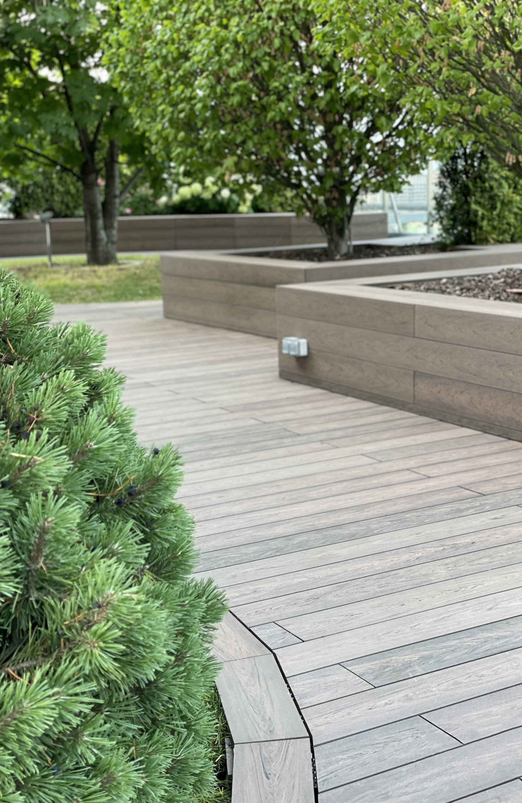 Rooftop landscape park in Kyiv with BRUGGAN Multicolor Wenge composite decking and integrated planters