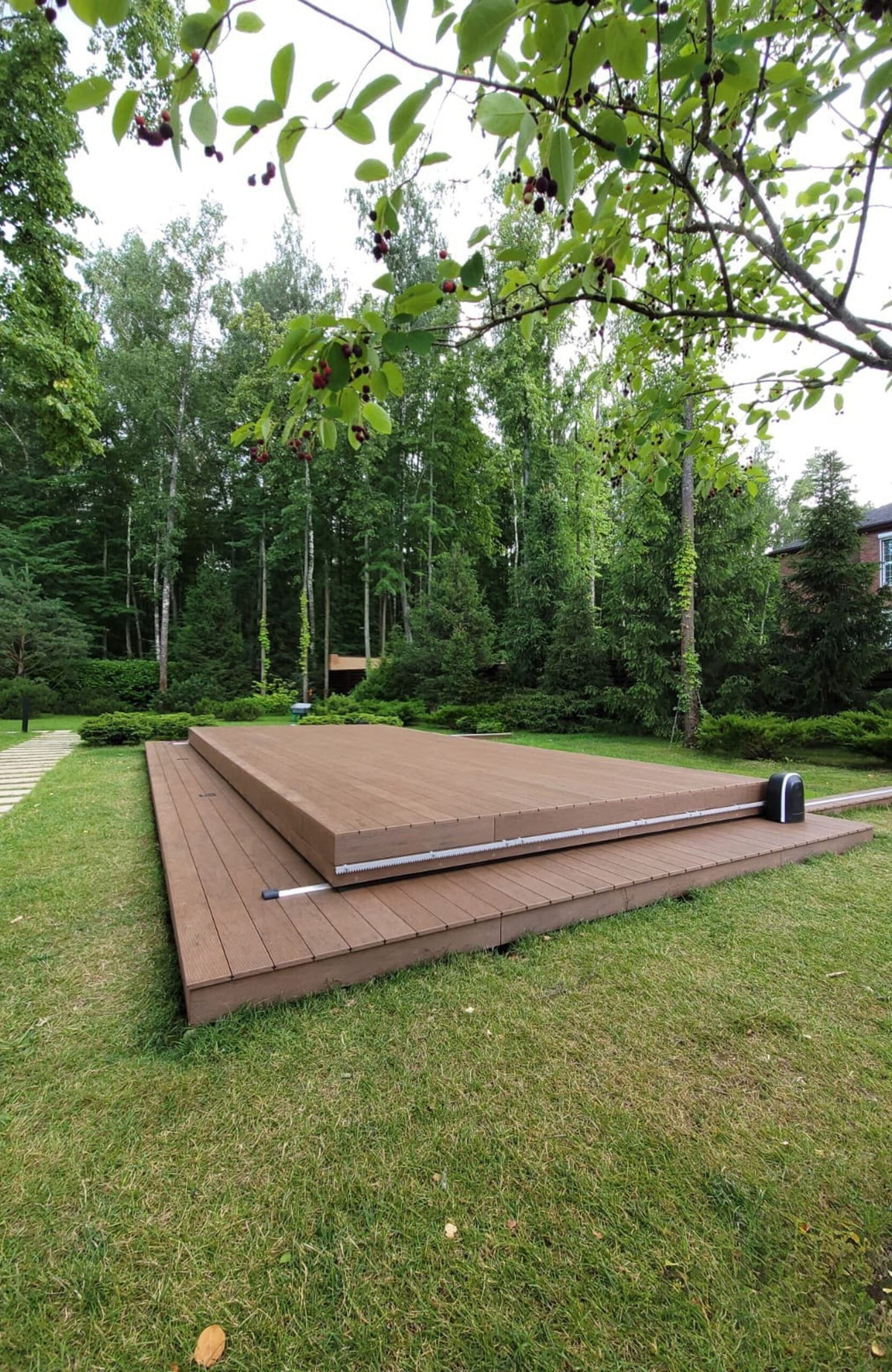 Private garden swimming pool with BRUGGAN Multicolor Wenge decking and sliding pool cover