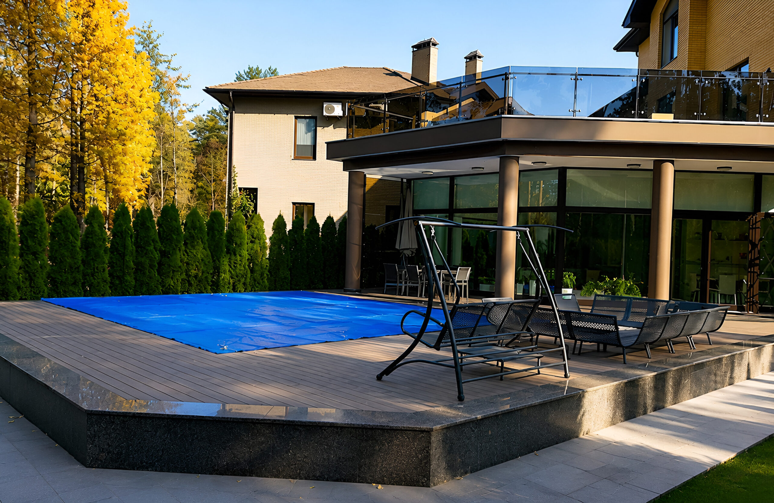 BRUGGAN Multicolor Wenge composite decking around a private swimming pool and outdoor lounge area