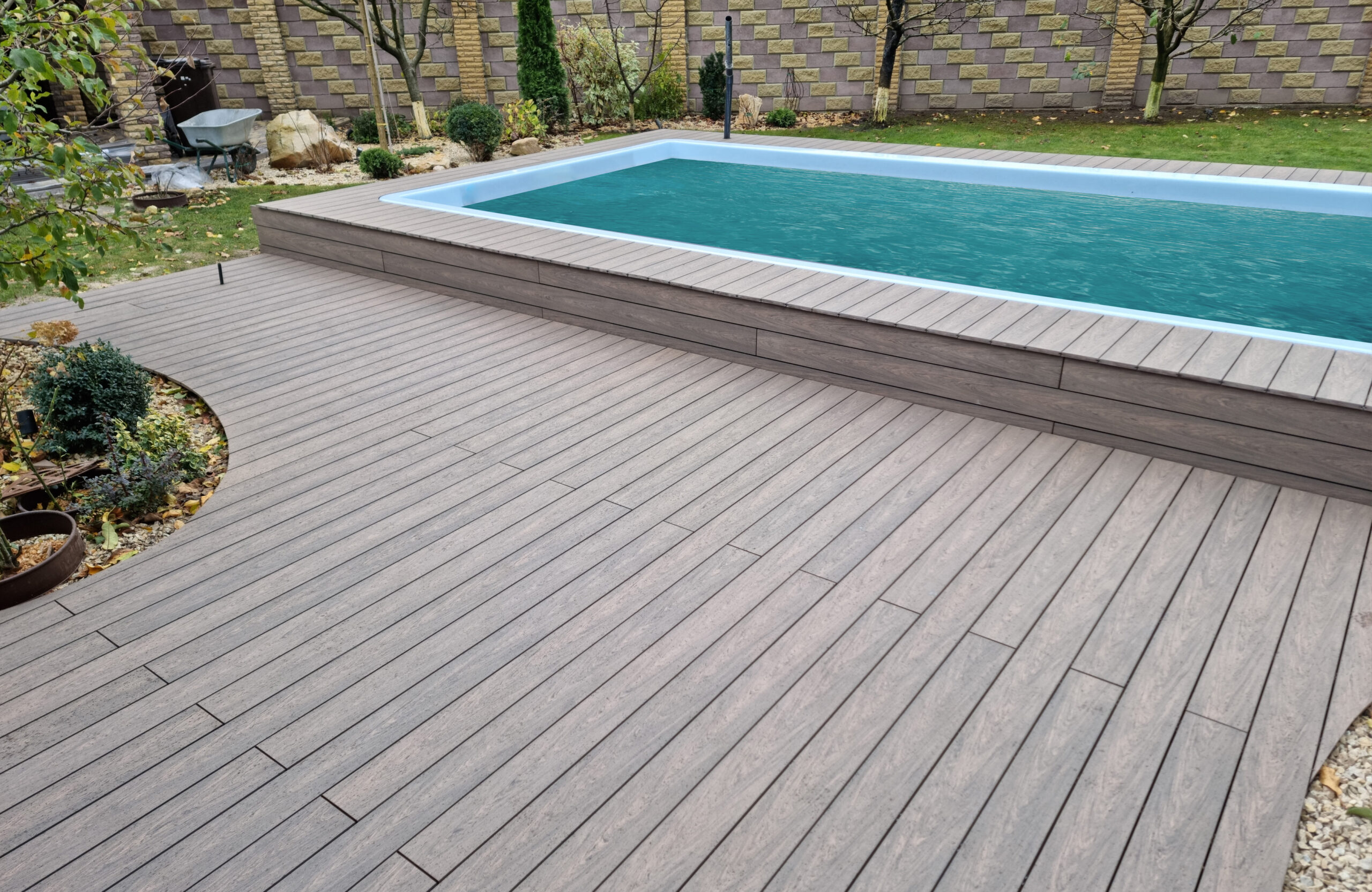 BRUGGAN Multicolor Wenge outdoor decking surrounding a raised swimming pool in a private backyard