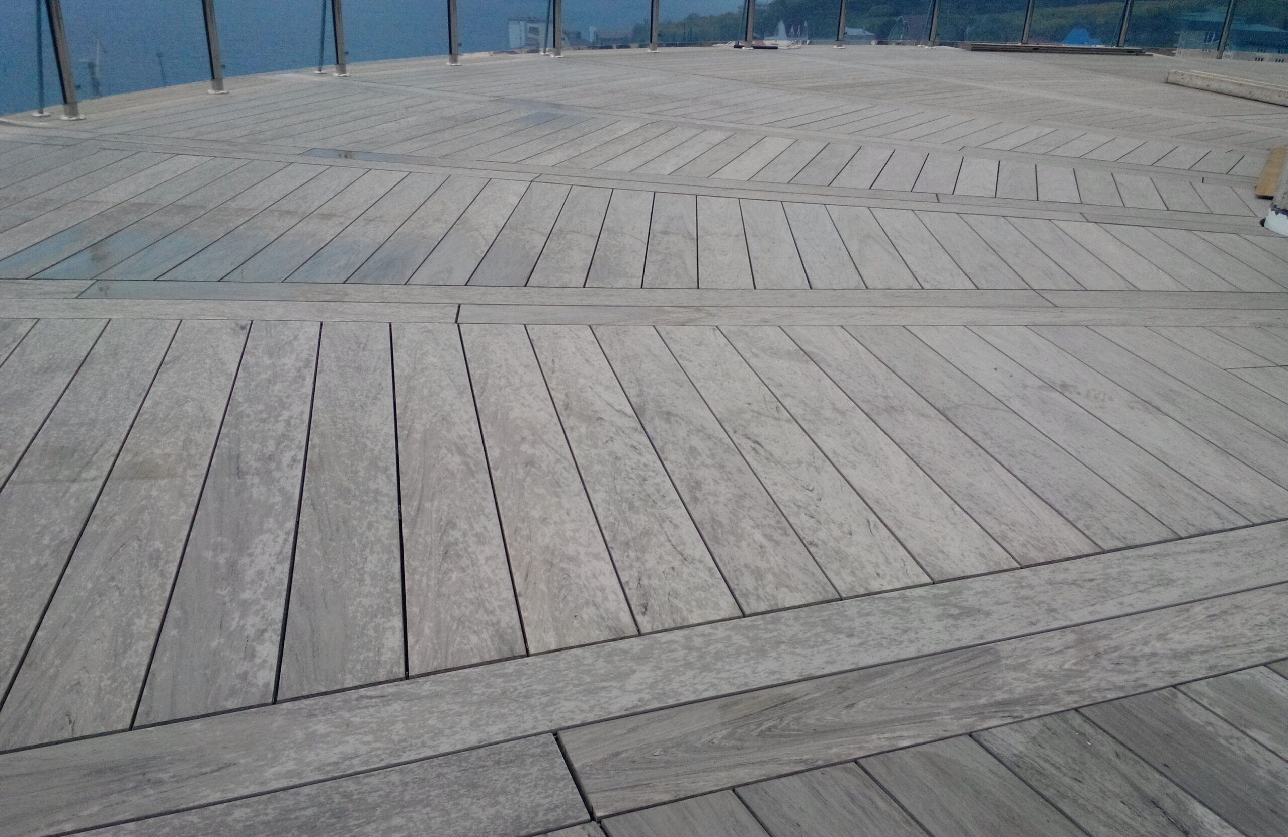 Spacious rooftop terrace finished with BRUGGAN Multicolor Wenge decking and glass railing