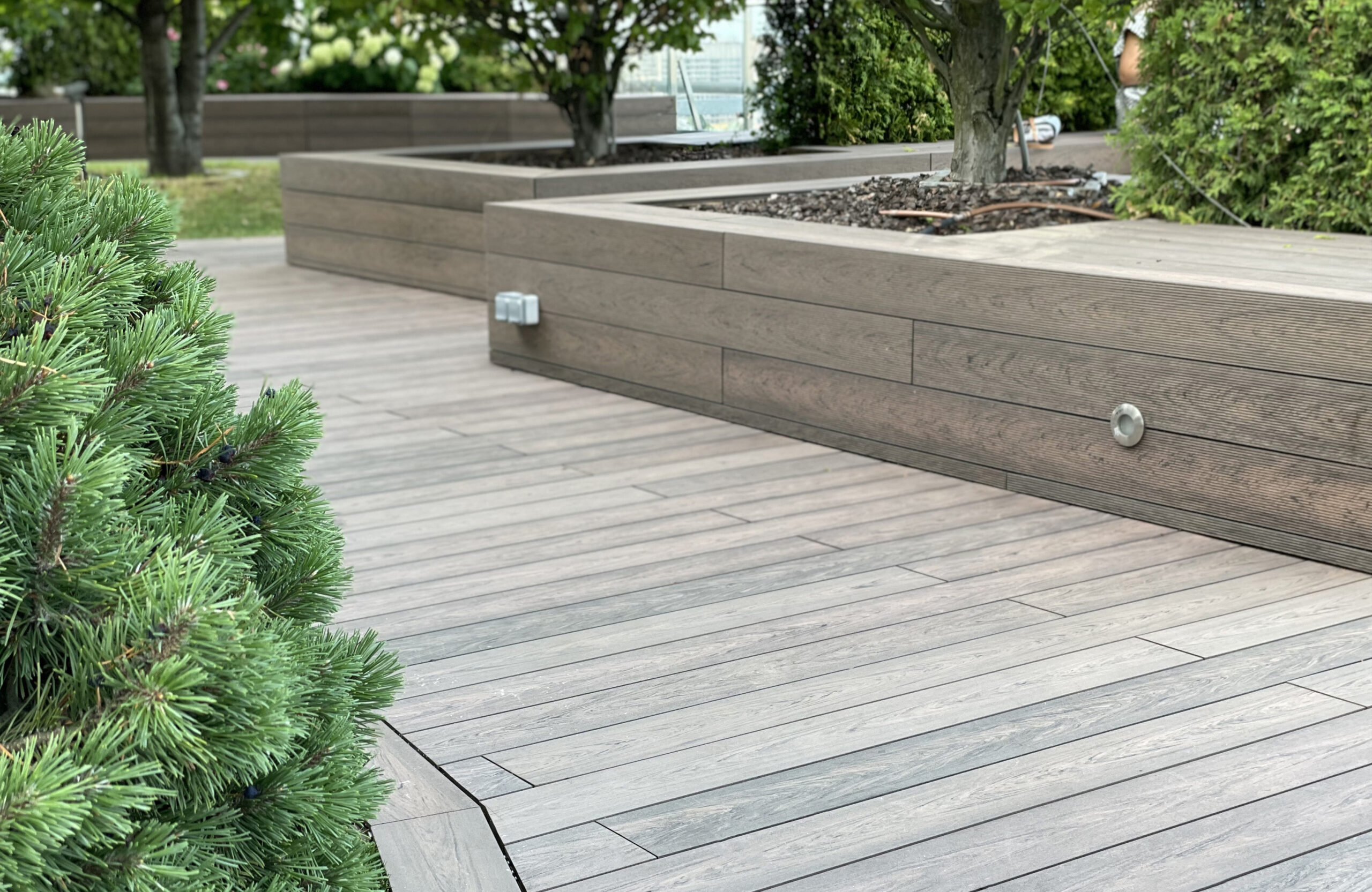 Rooftop landscape park in Kyiv with BRUGGAN Multicolor Wenge composite decking and integrated planters
