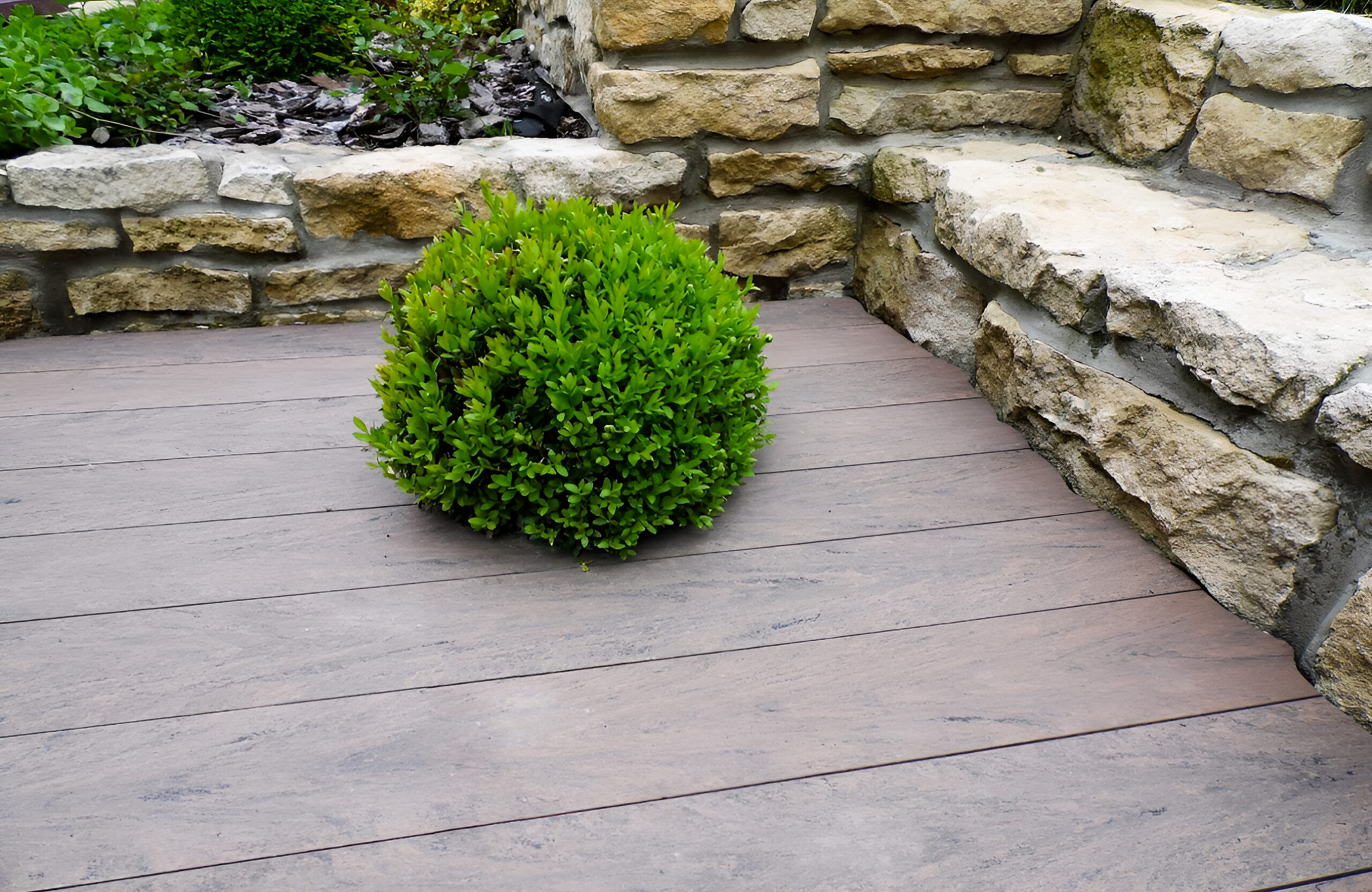 Garden terrace finished with BRUGGAN Multicolor Wenge decking and decorative stone landscaping