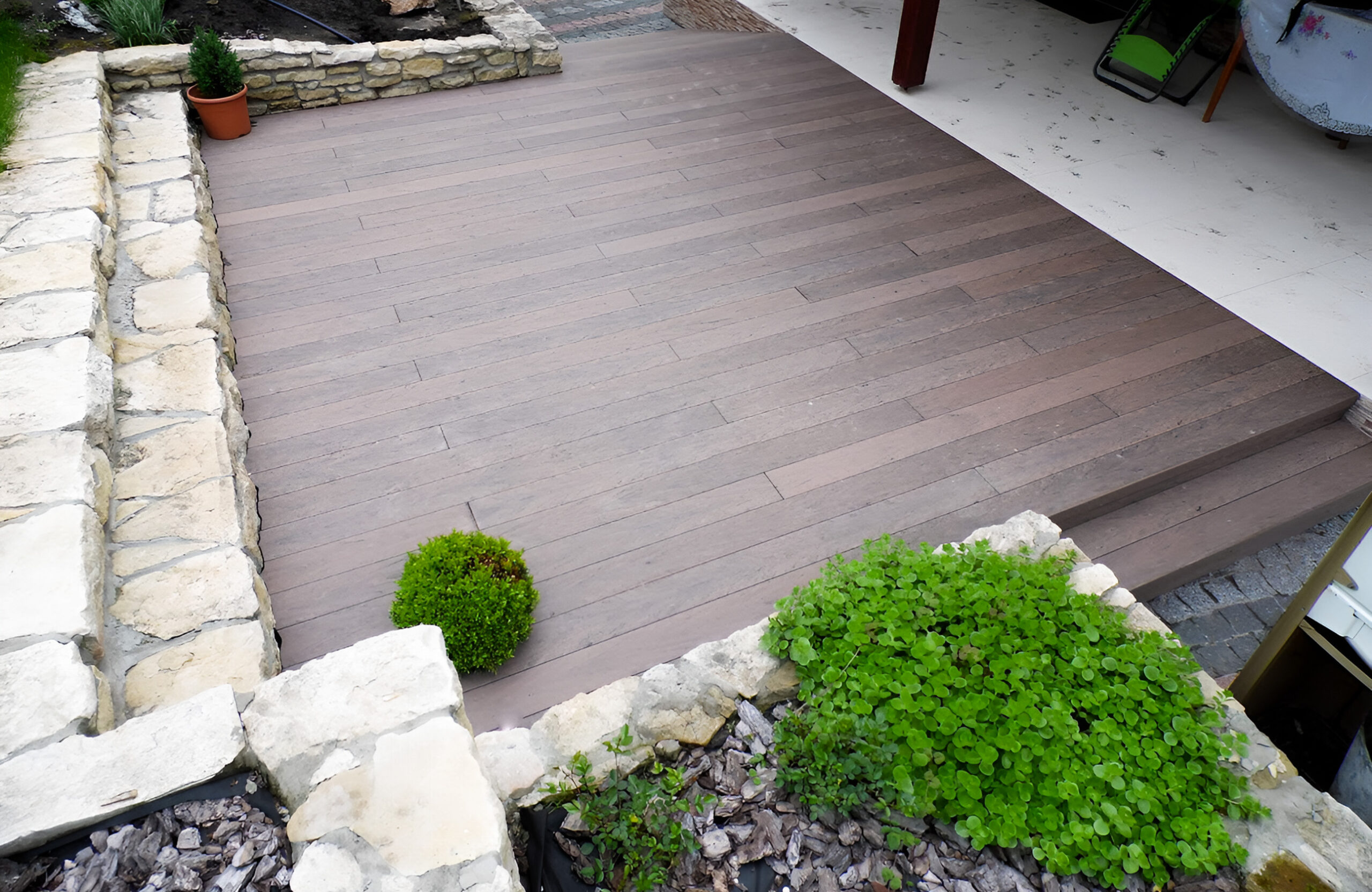 Garden terrace finished with BRUGGAN Multicolor Wenge decking and decorative stone landscaping