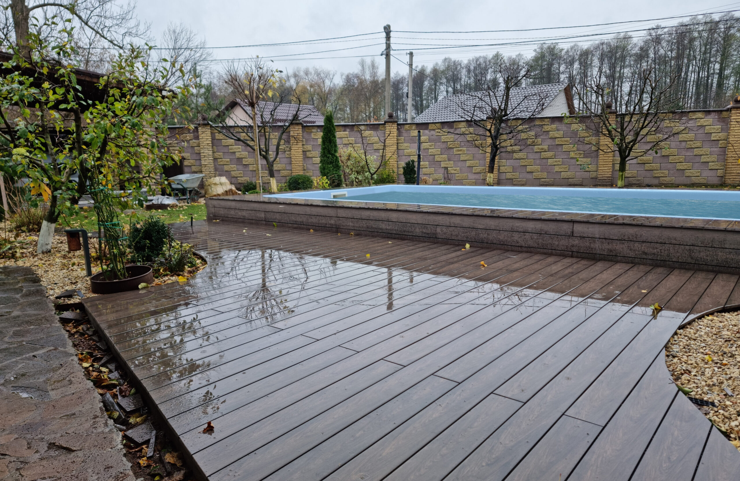 BRUGGAN Multicolor Wenge outdoor decking surrounding a raised swimming pool in a private backyard