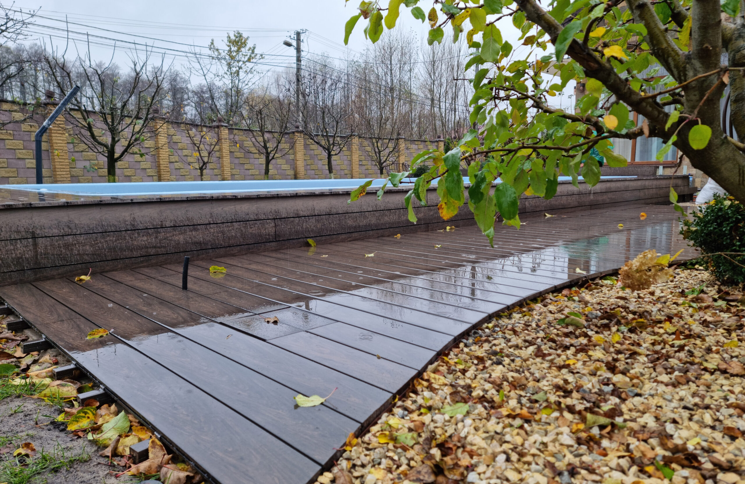 BRUGGAN Multicolor Wenge outdoor decking surrounding a raised swimming pool in a private backyard