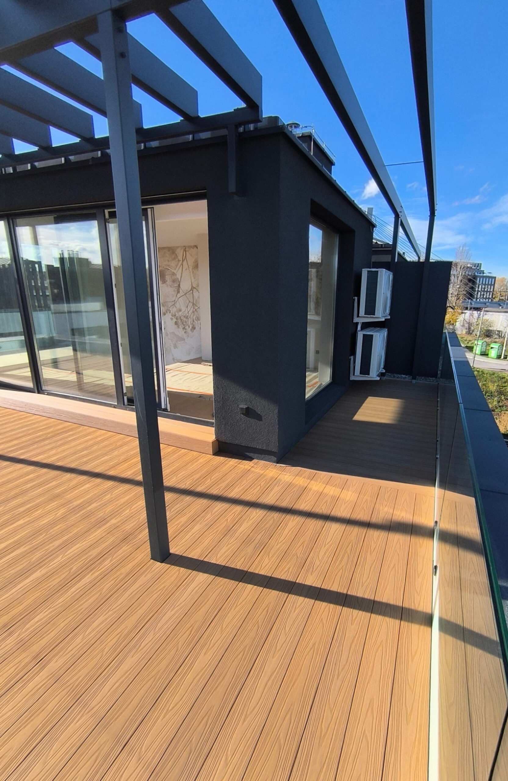 Legro Maple composite decking on a sunny rooftop terrace with modern pergola
