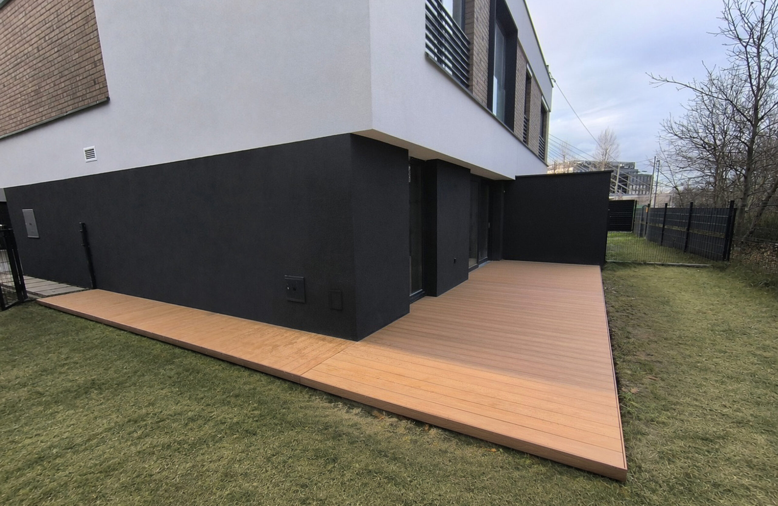 Legro Maple composite decking installed around a modern house and garden terrace