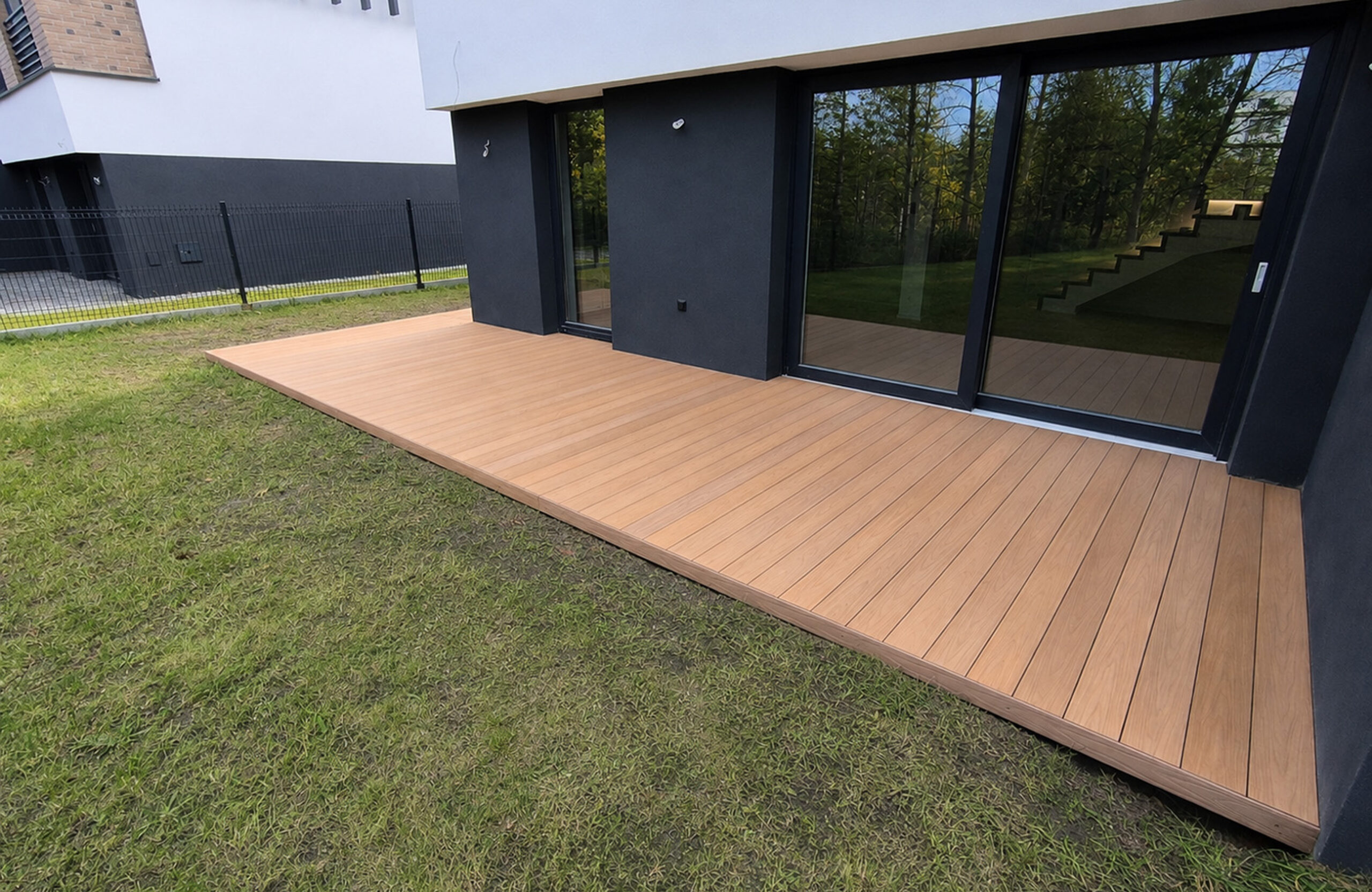 Legro Maple composite decking installed around a modern house and garden terrace