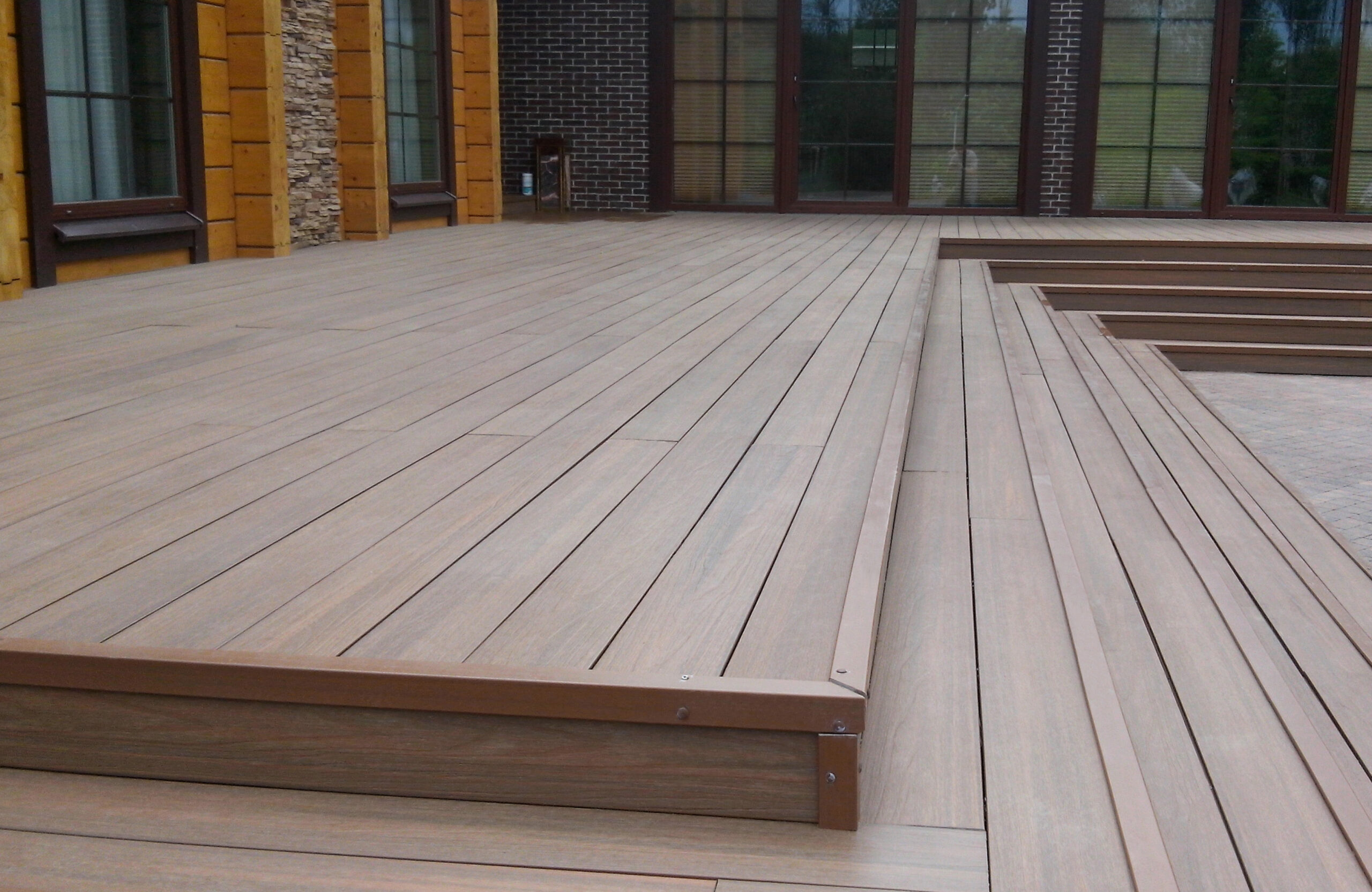 LEGRO teak composite decking terrace with integrated steps and modern house exterior