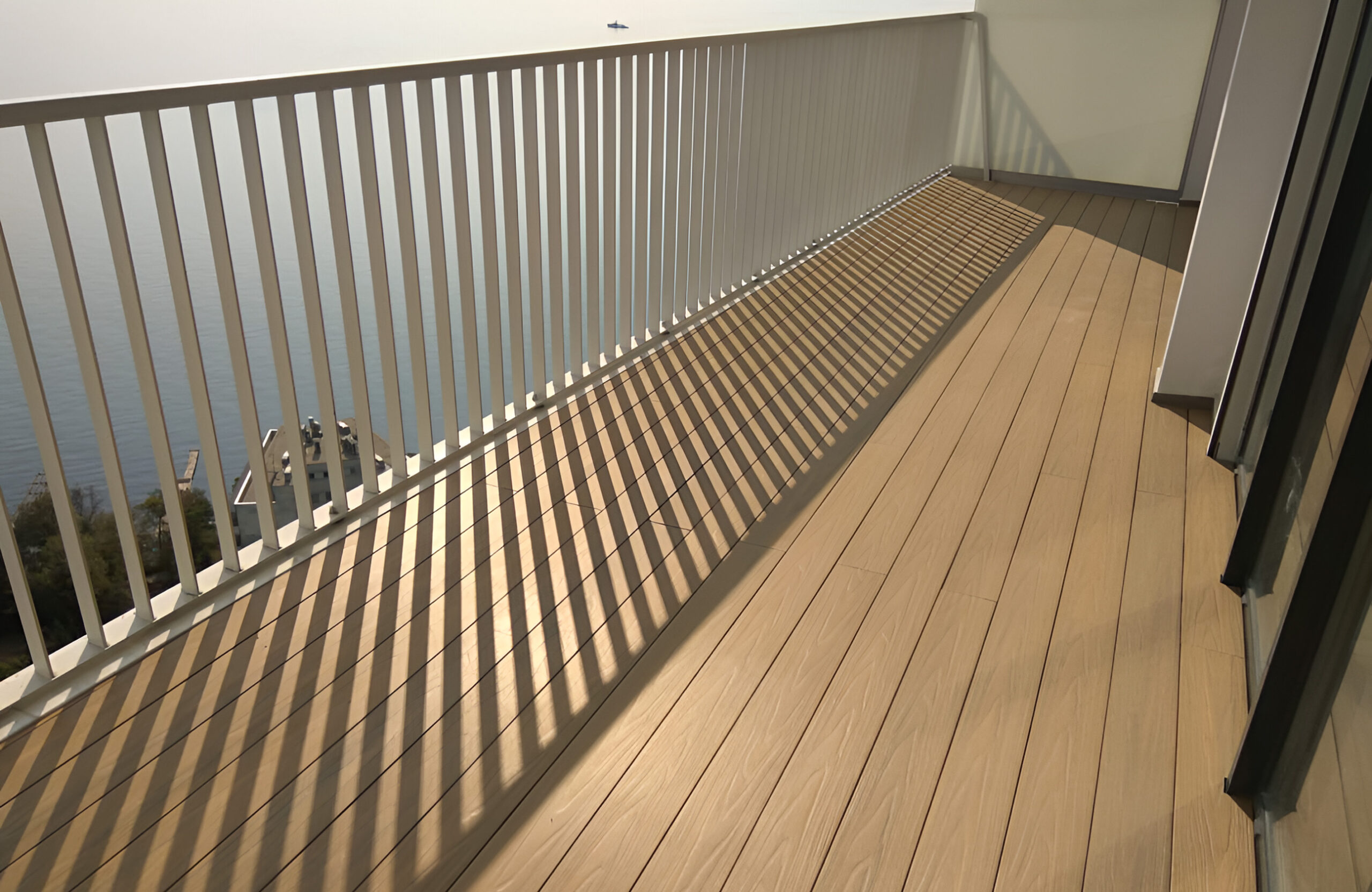 LEGRO teak composite decking installed on a modern balcony with white metal railing
