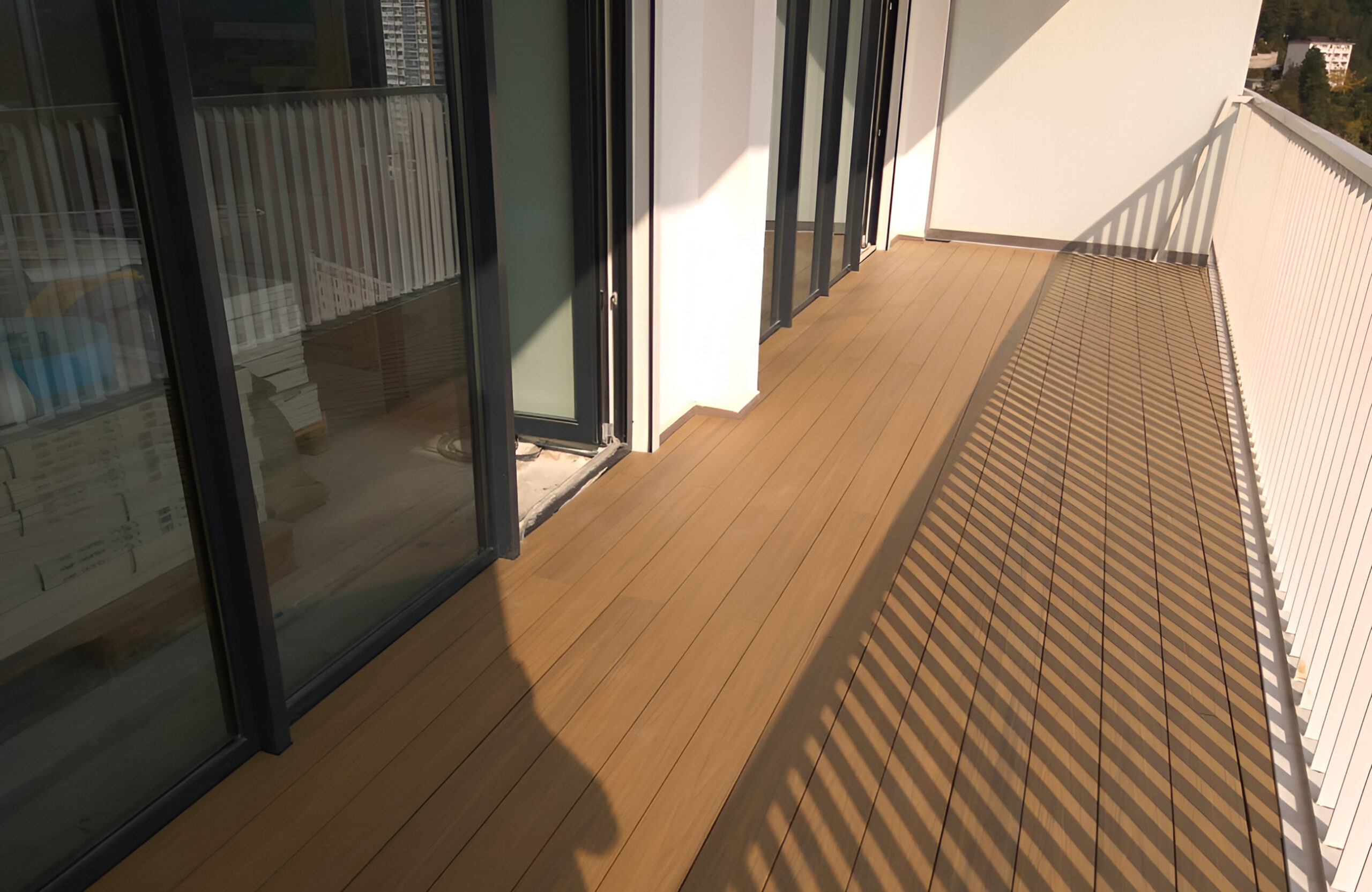 Modern residential balcony with LEGRO teak WPC decking and white railing