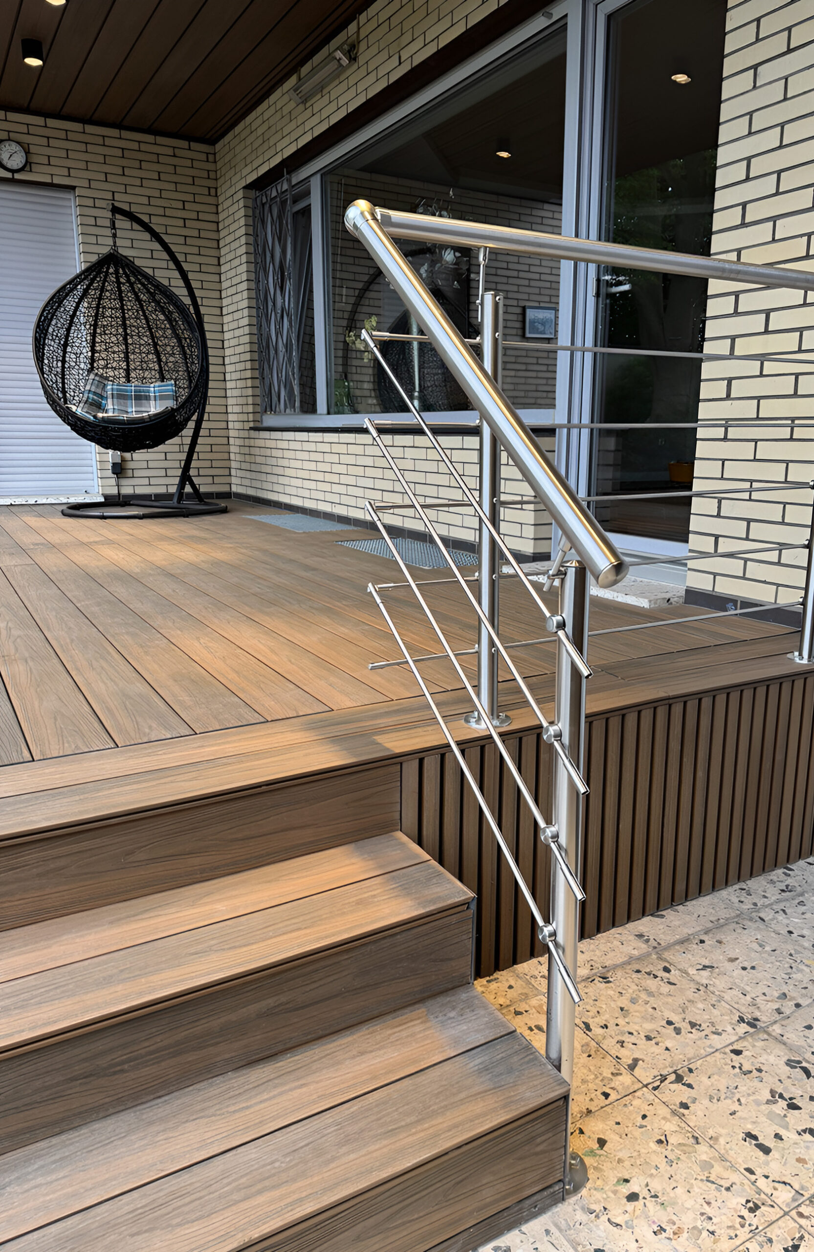 LEGRO teak composite decking terrace with matching steps, stainless steel railing and modern outdoor seating