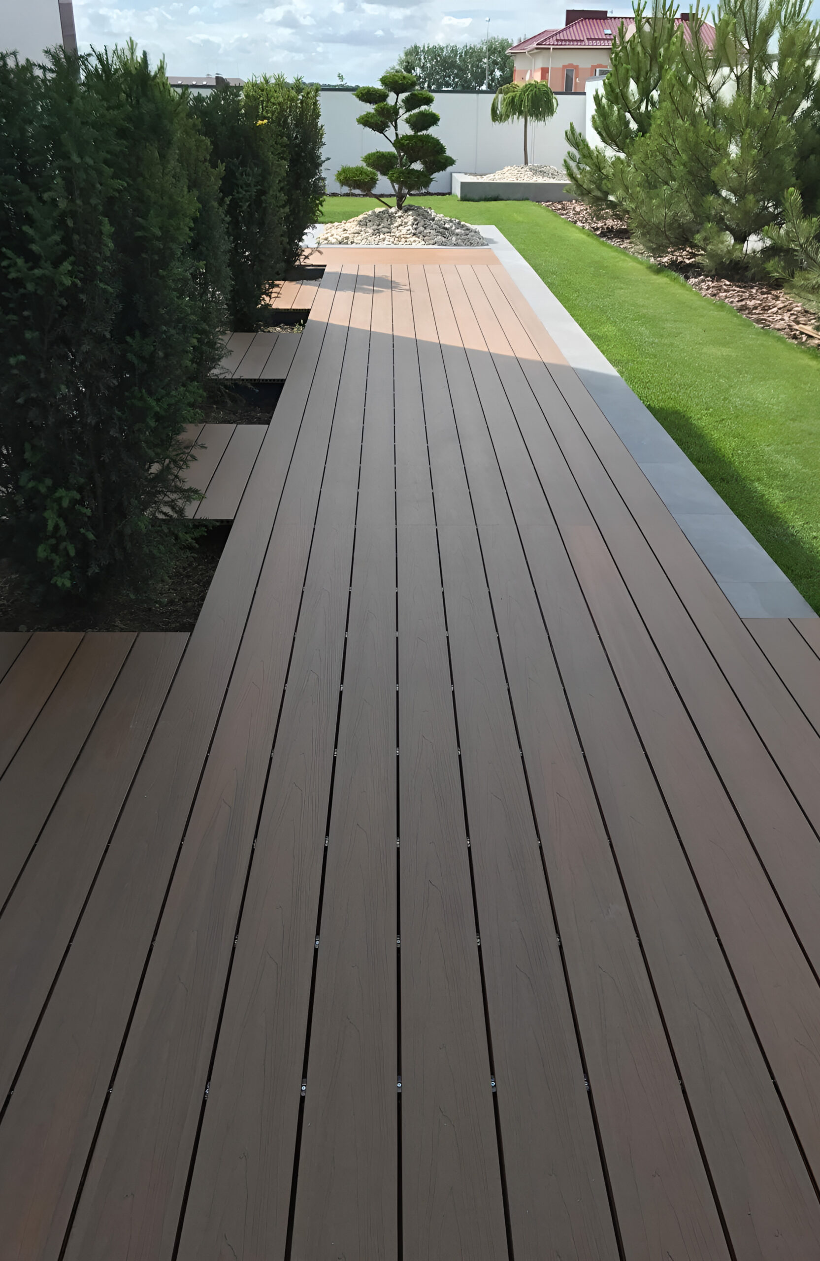 LEGRO teak composite decking walkway surrounded by landscaped garden and greenery