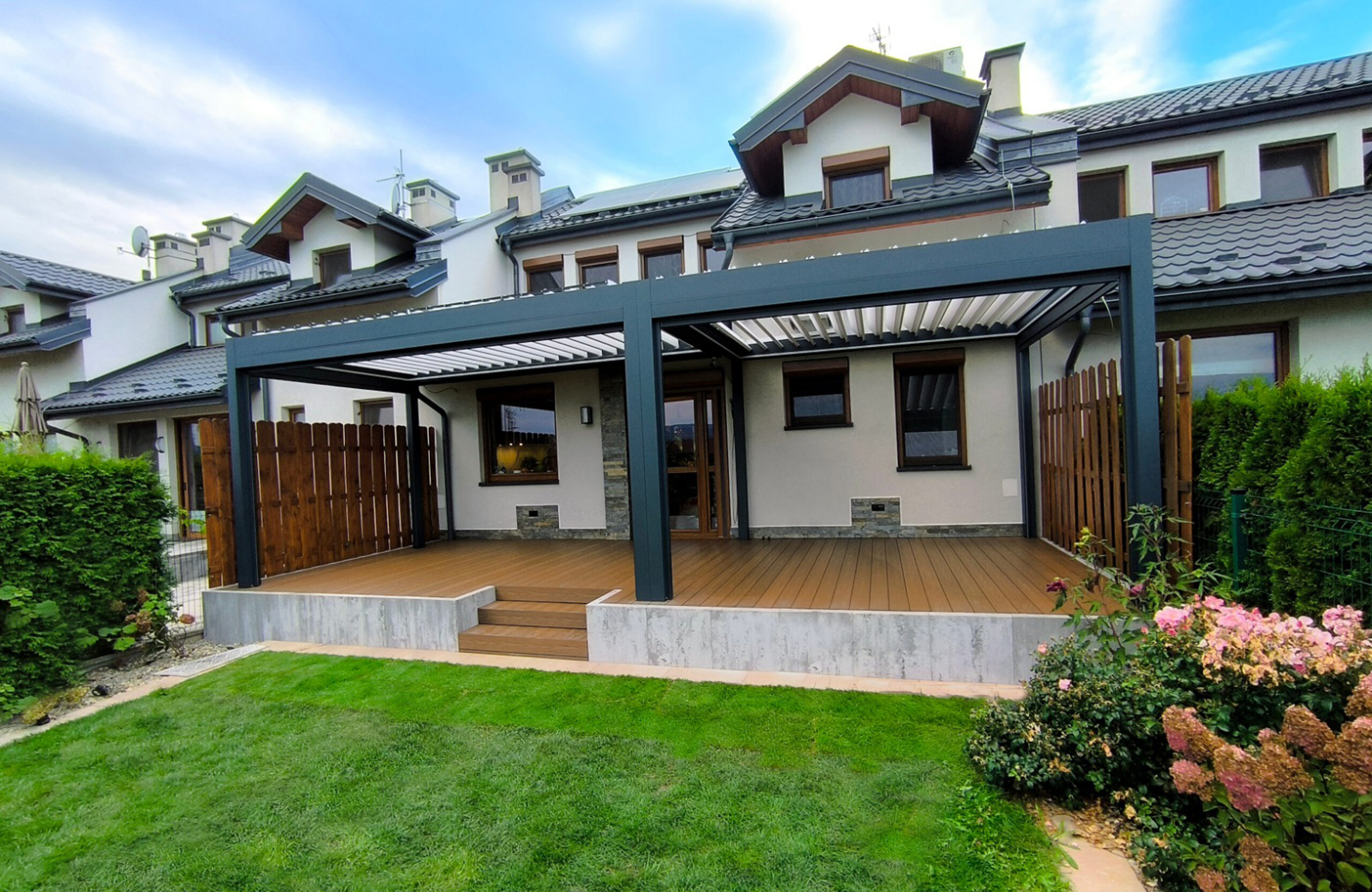Composite decking terrace with black modern louvered pergola roof
