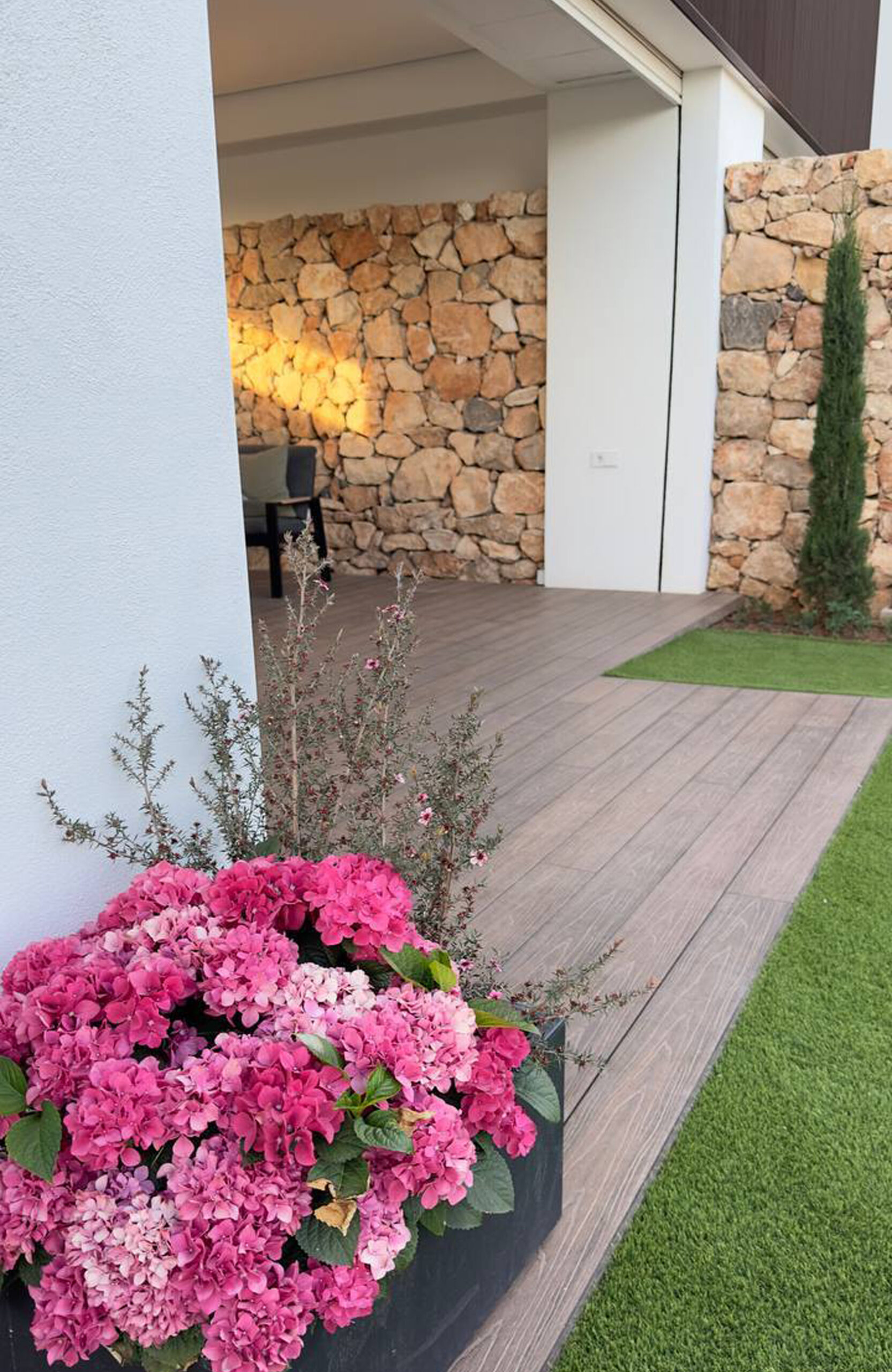 LEGRO walnut composite decking terrace with flowers and natural stone walls