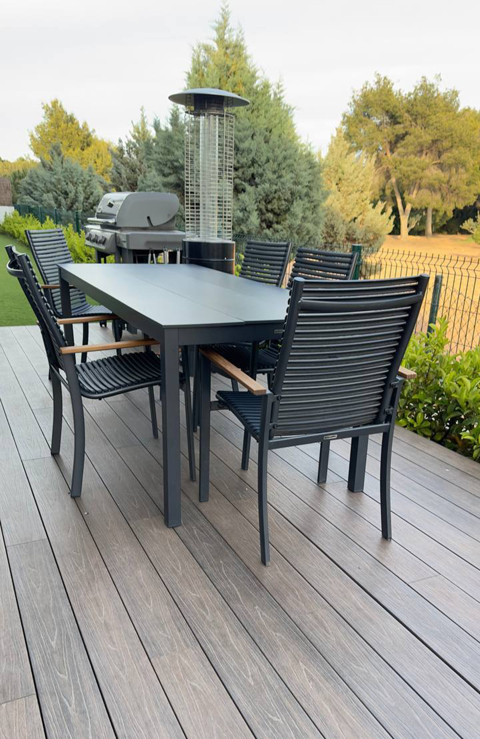 Outdoor dining area on LEGRO walnut WPC decking with garden furniture and barbecue