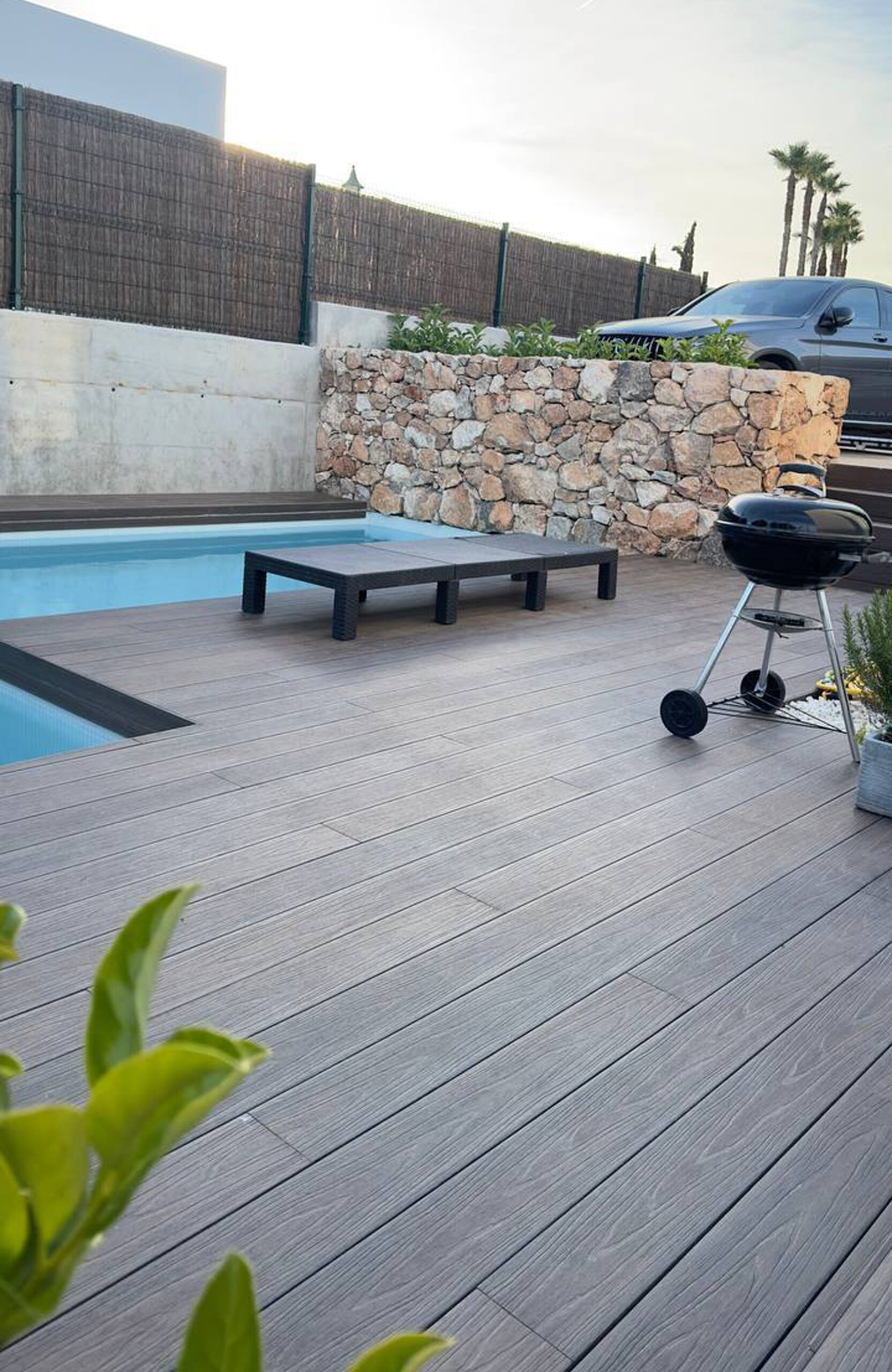 LEGRO walnut composite pool decking surrounding a modern outdoor swimming pool