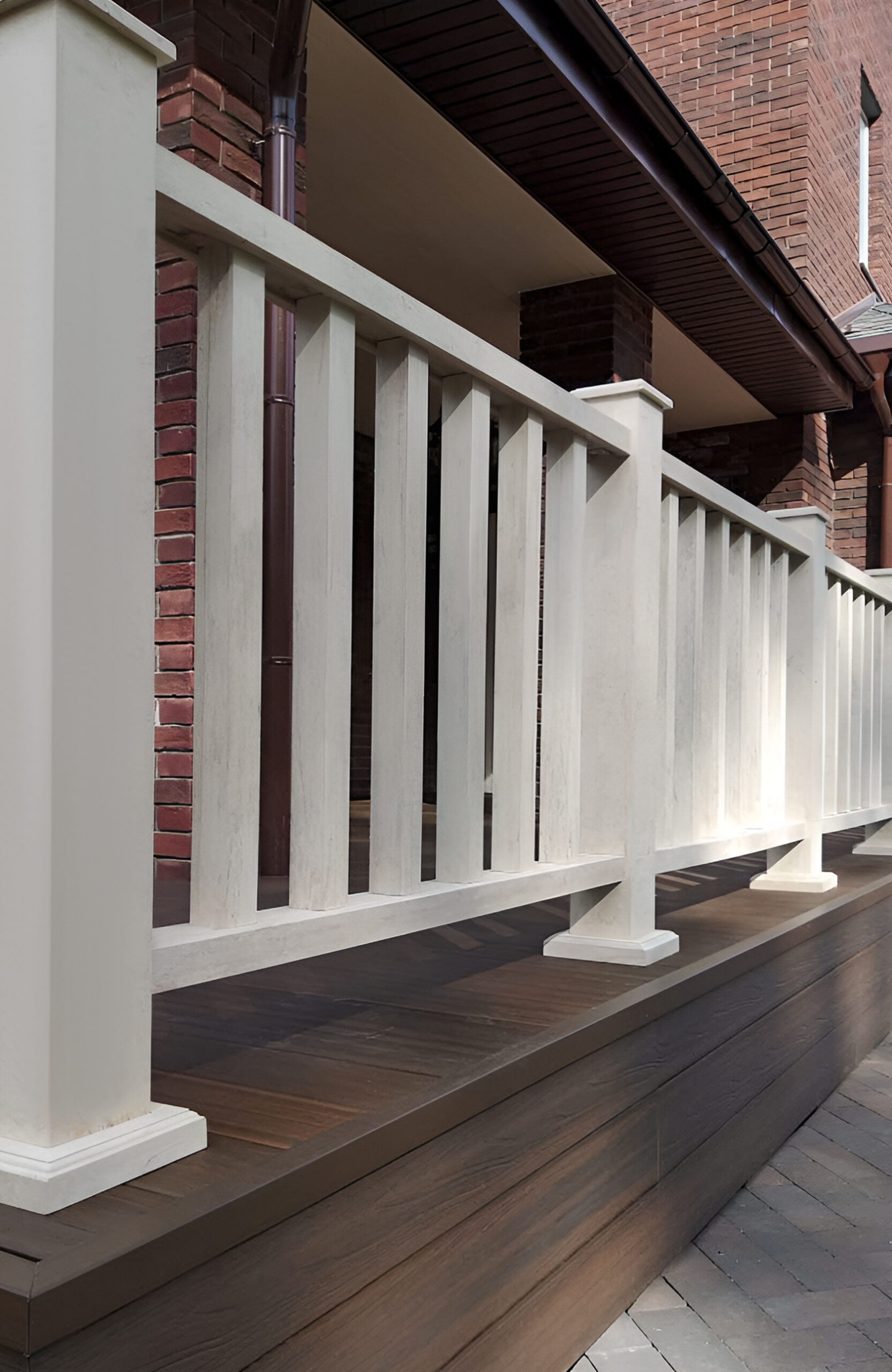 Close-up of LEGRO walnut composite decking with white terrace railing