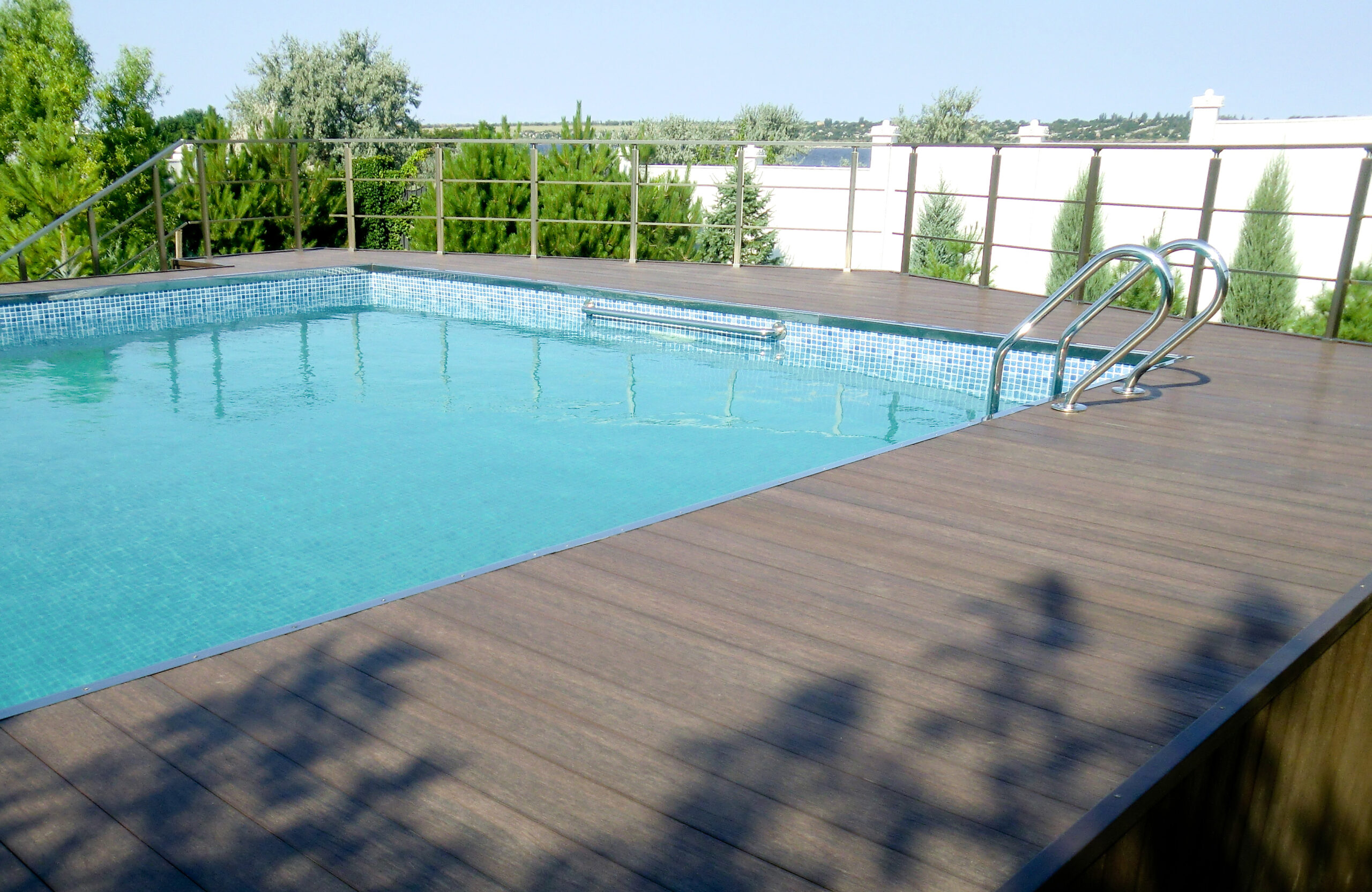 Outdoor swimming pool with LEGRO walnut composite decking and metal railings