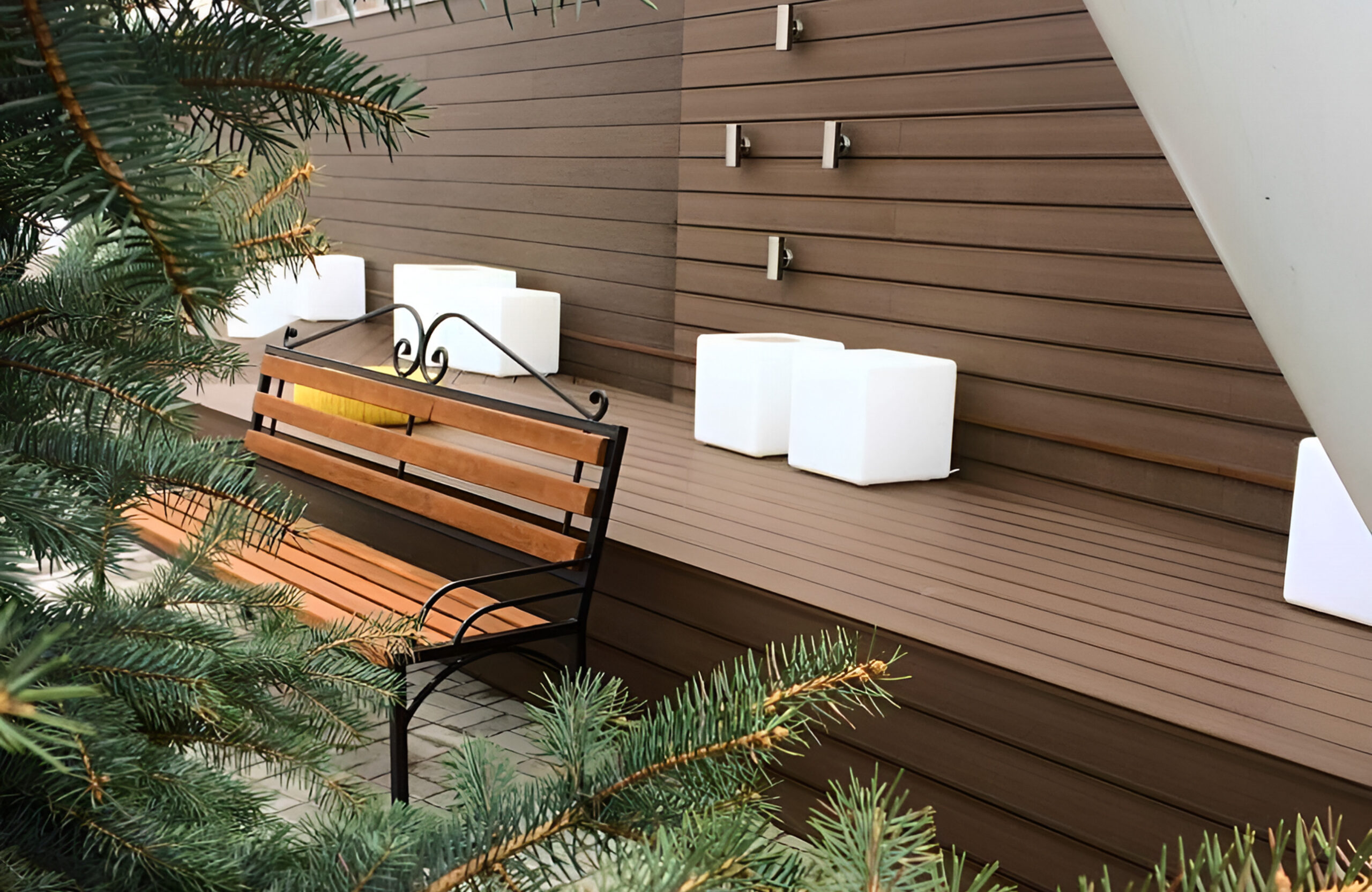 Outdoor seating area with brown composite wall cladding, built-in bench and decorative planters