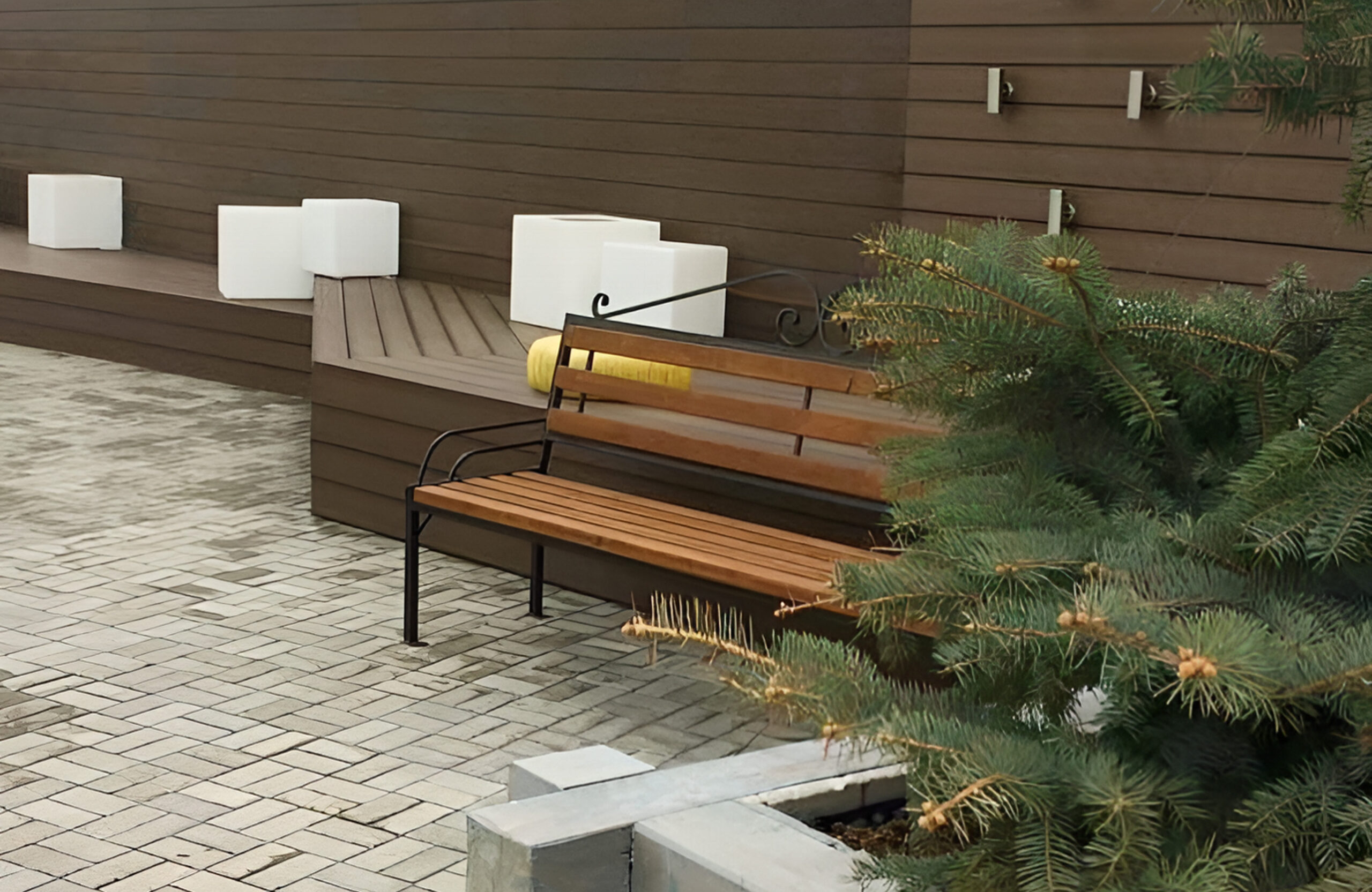 Landscaped outdoor area with brown composite cladding, integrated bench seating and evergreen trees